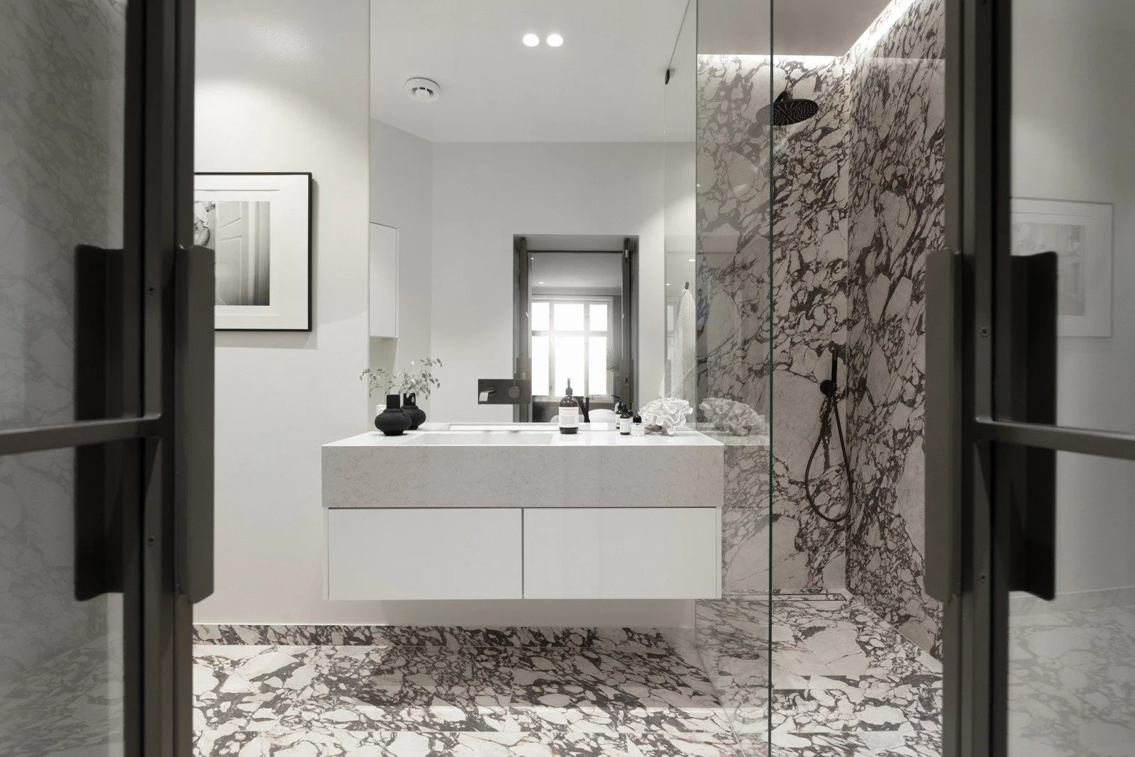 Elegant baderom med Calacatta-inspirerte flater, spesialtilpasset servantinnredning og glassdusj.
