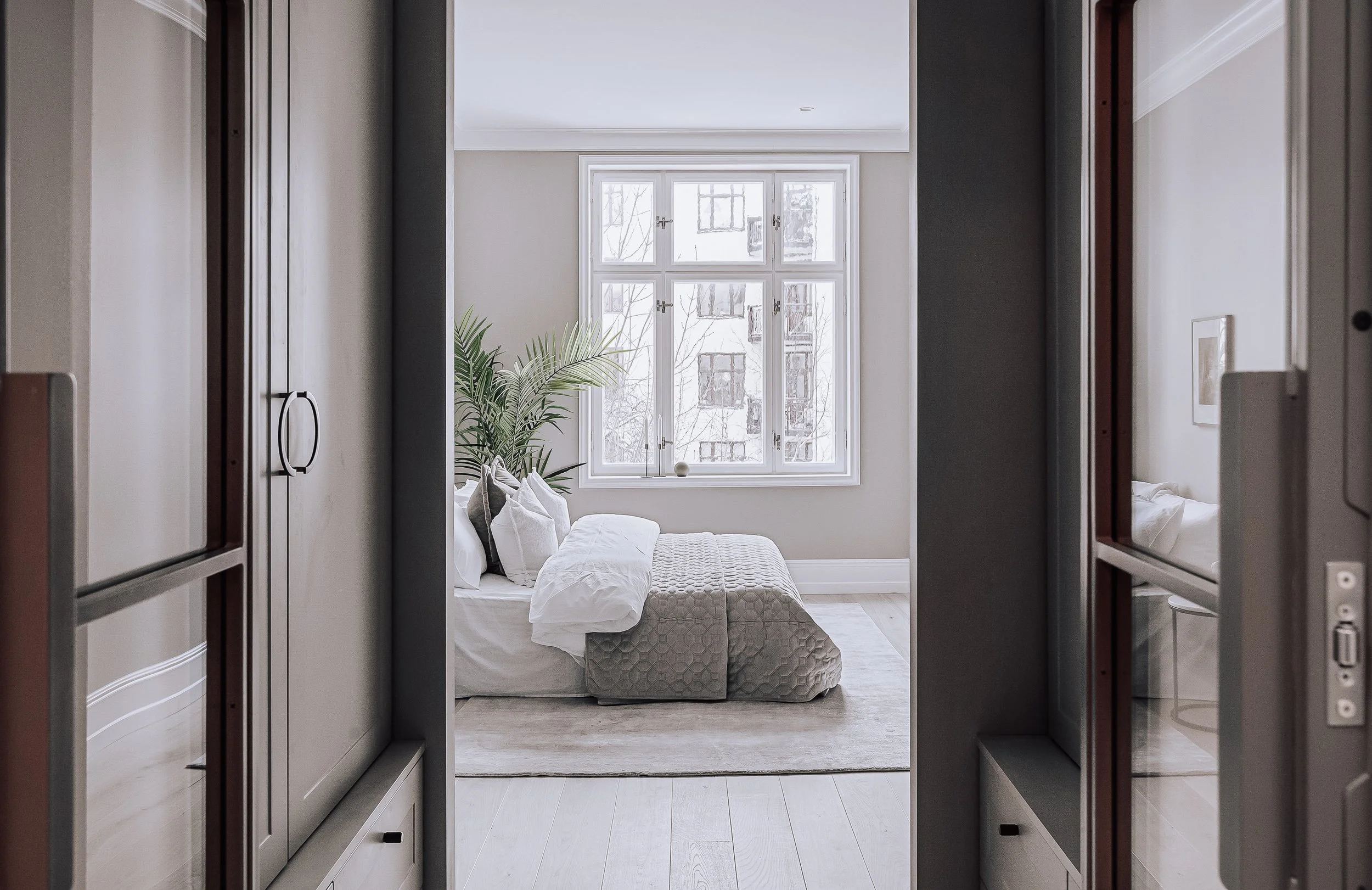 Soverom i myke, lyse toner med teksturerte materialer og adkomst til en-suite bad