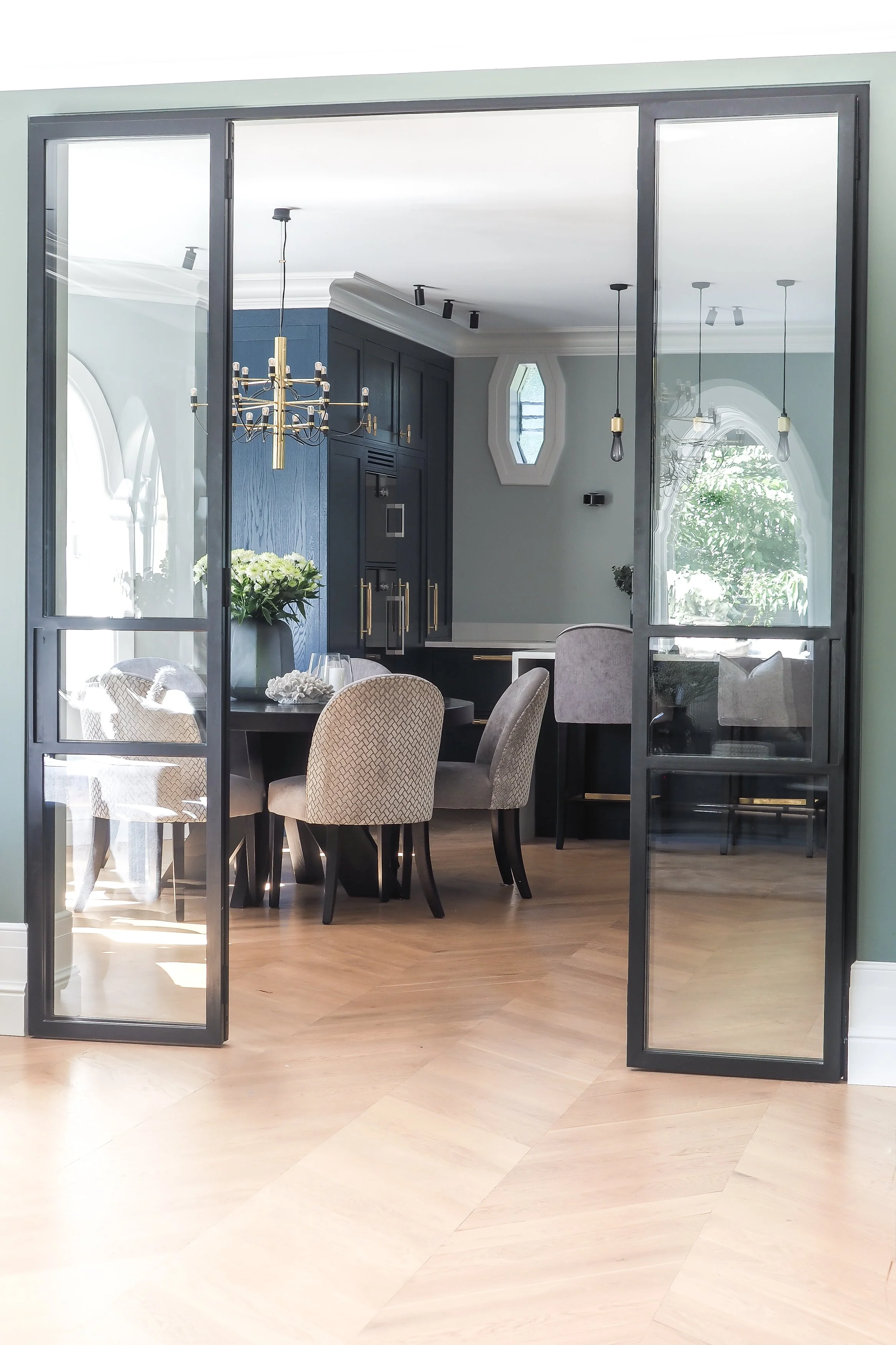 Spisestue med spesialtilpasset glassdør, mørke detaljer og nøye utvalgt dekor.