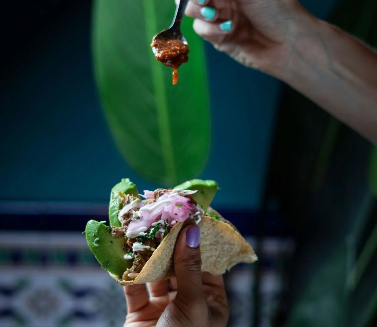 Primer pla d’un taco amb guacamole i ceba vermella adobada a Six Seis