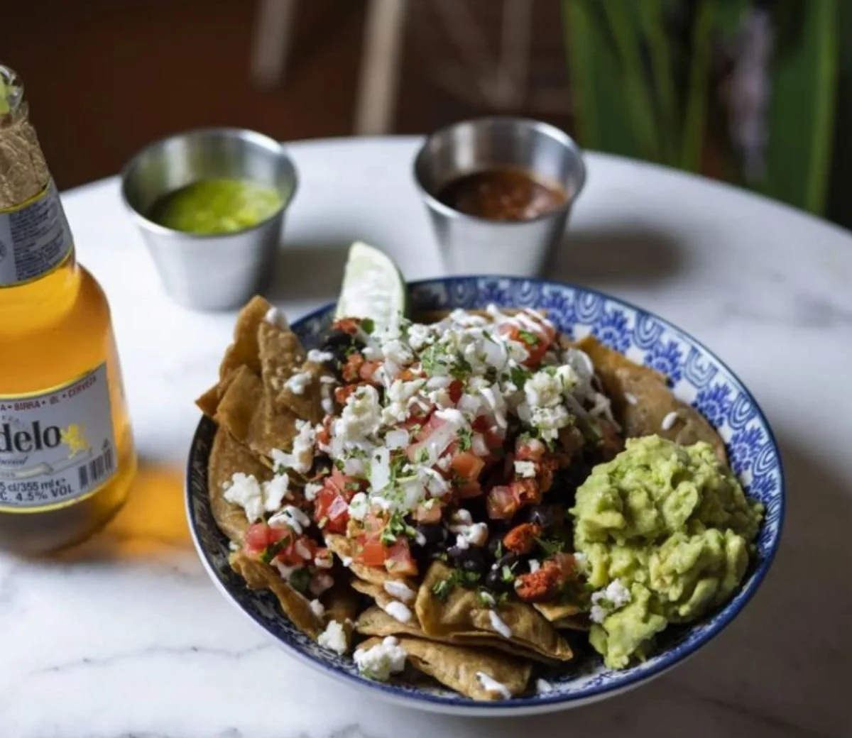 Mexican bowl topped with guacamole, chopped toppings and cream at Six Seis
