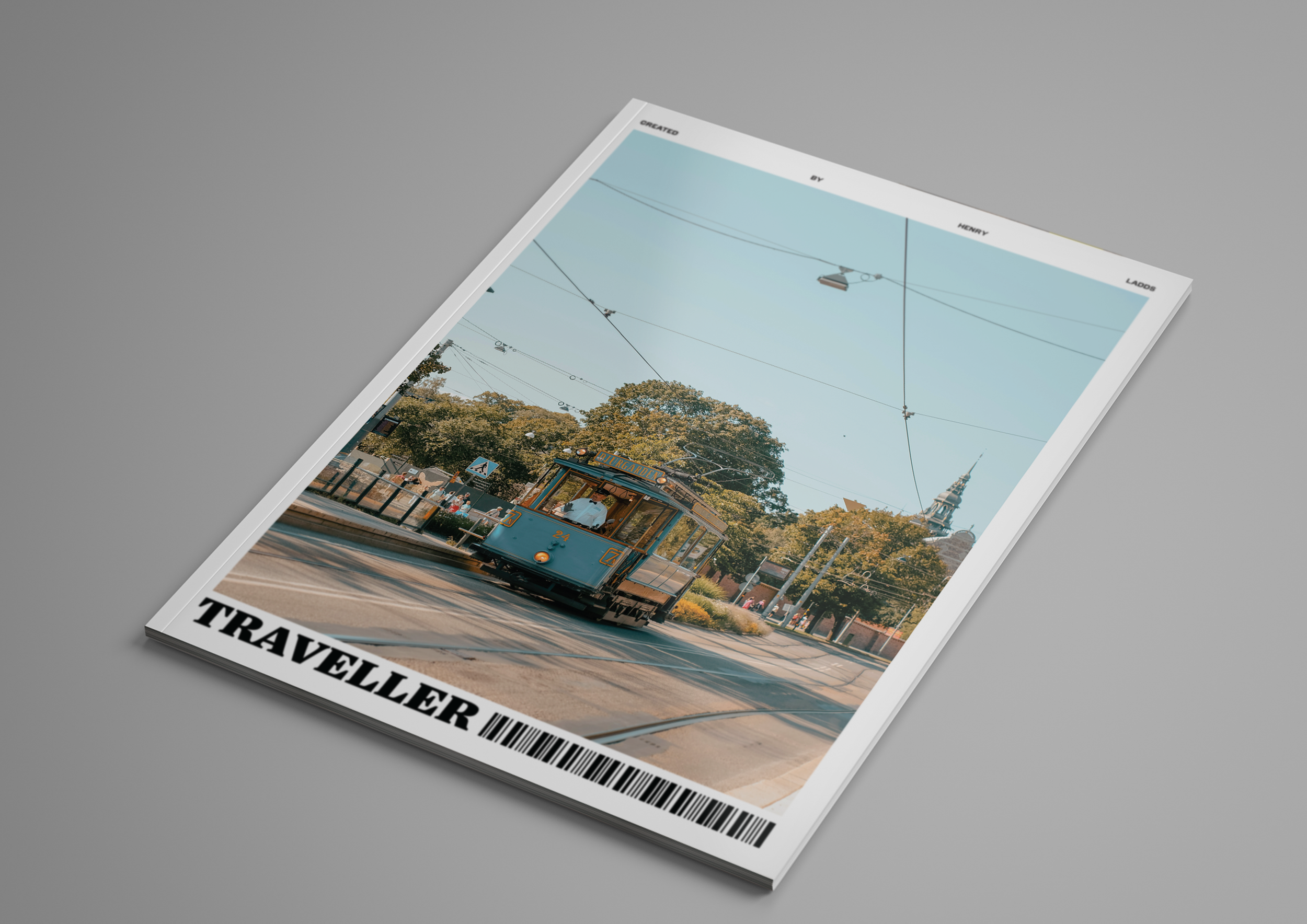 A magazine cover showing a vintage tram moving along a street, with trees and a church steeple in the background. The magazine title, partially visible, reads "TRAVELER."