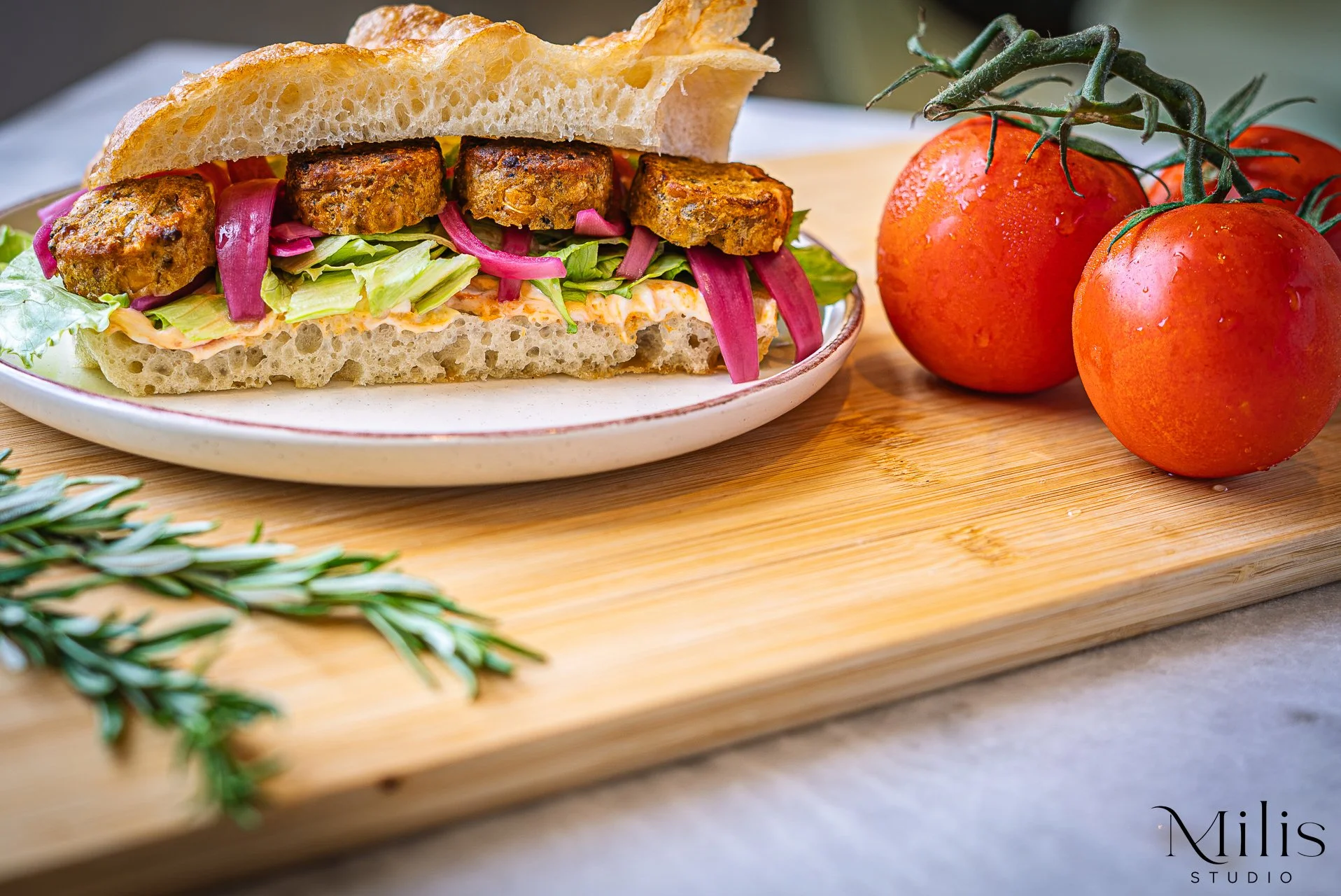 Vegetarian focaccia sandwich with tomatoes photographed by Milis Studio