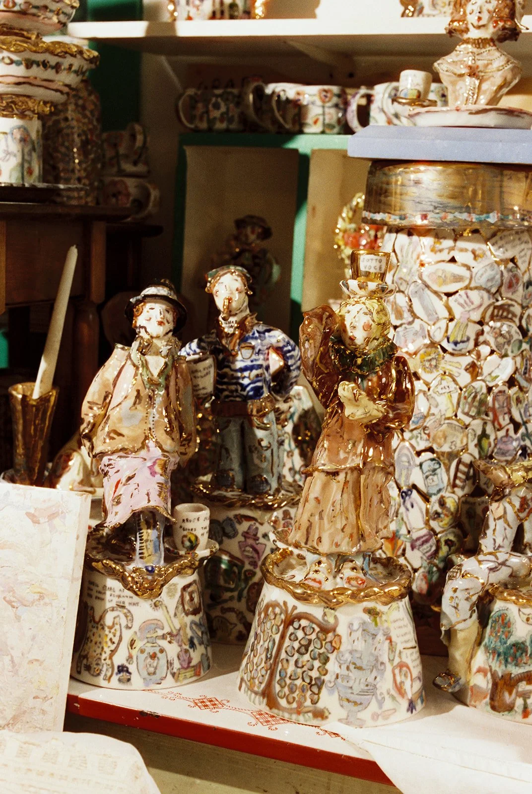 Collection of ornate ceramic figures in Dominique Ostuni artist studio