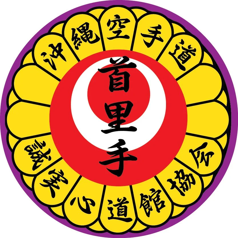 A circular emblem with black Chinese characters in the center, surrounded by a white and red inner circle, yellow petal-like shapes with black characters around the perimeter, and a purple outer border.
