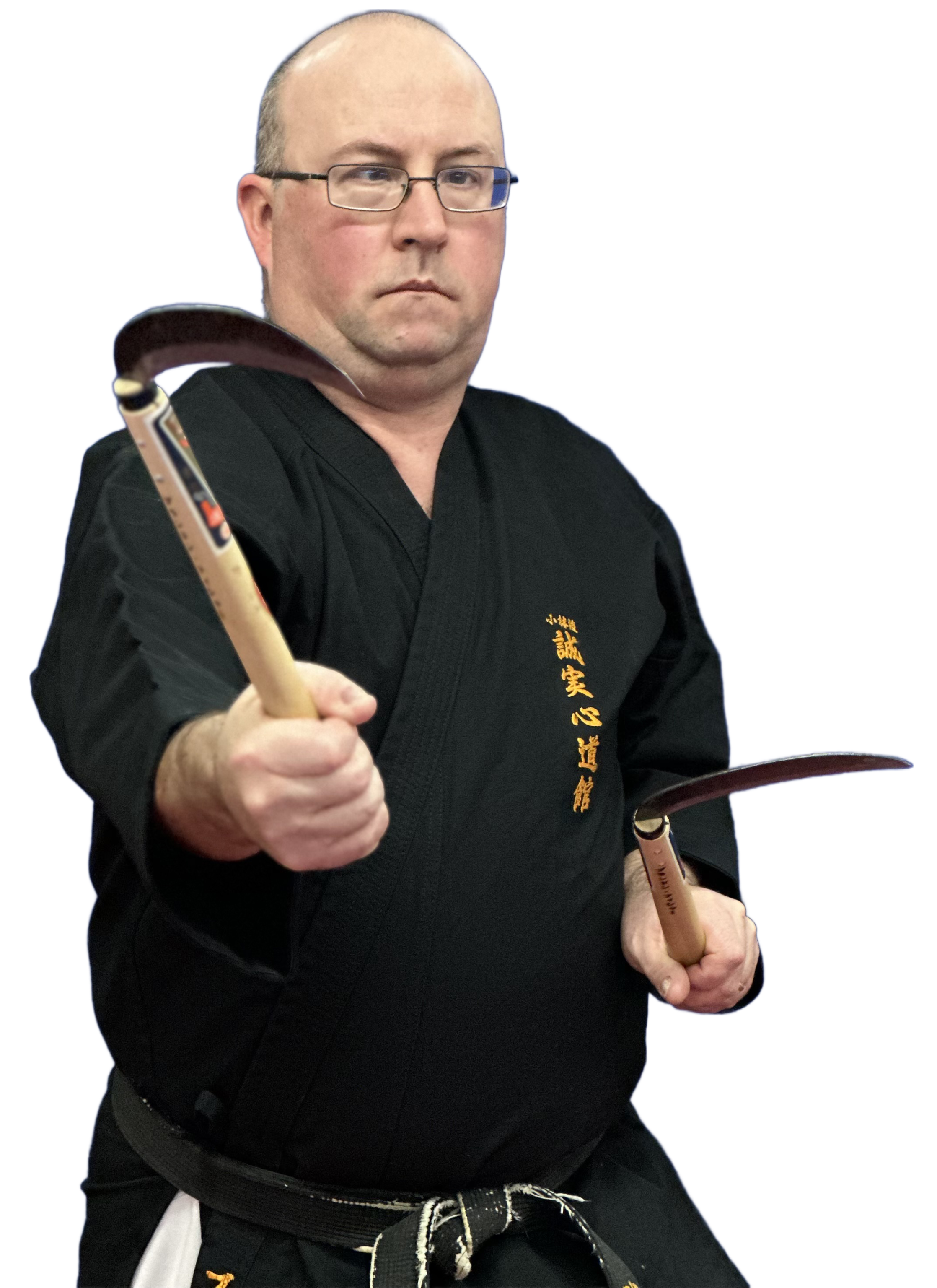 A person with glasses and a bald head wearing a black martial arts uniform holding a wooden weapon, possibly a bo staff, with Japanese characters embroidered in gold on the uniform, and a blue background.