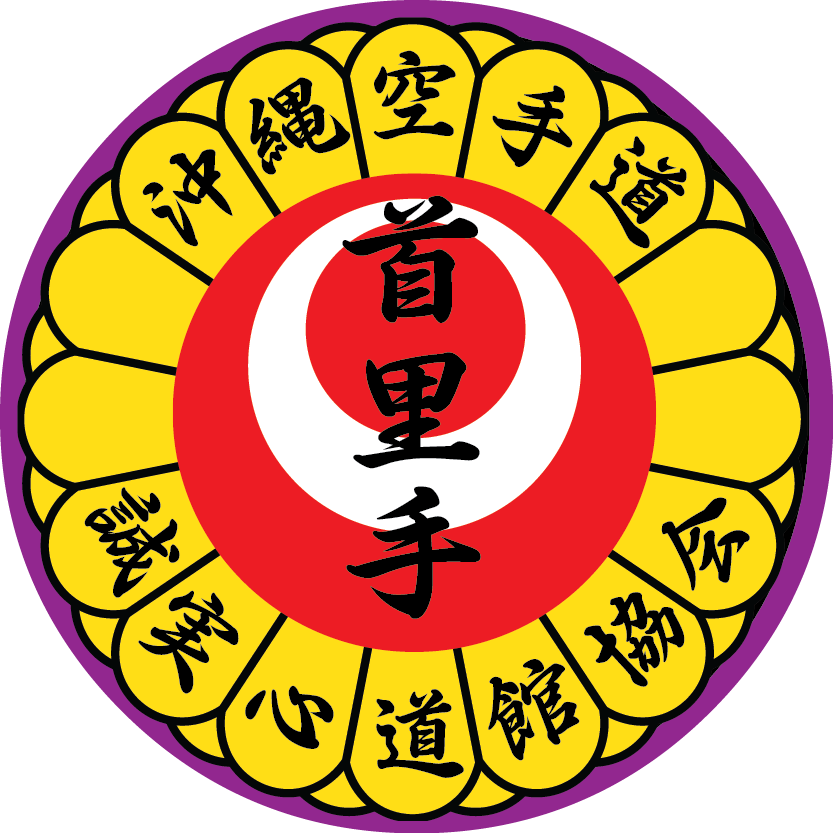 A circular emblem with a purple border, featuring a yellow flower-like border with black Japanese characters, a white circle with a red background in the center, and black Japanese characters over the red and white areas.