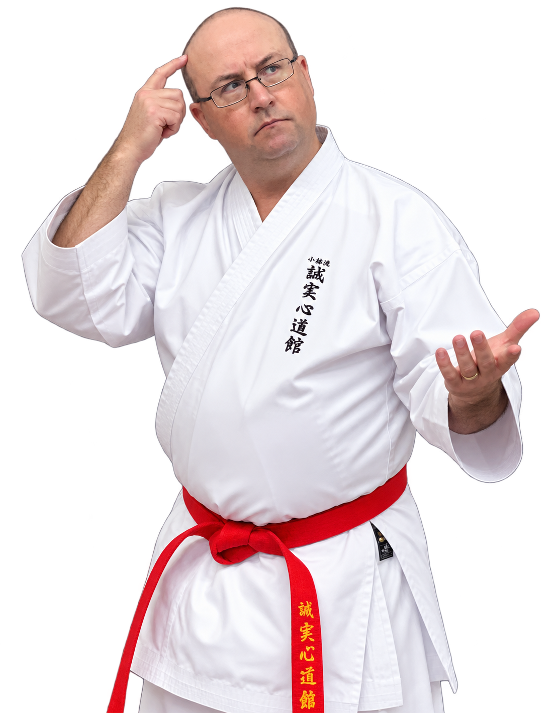 Man dressed in a traditional martial arts uniform, standing with one hand raised and the other hand on his temple, wearing glasses and a red belt with Japanese characters.