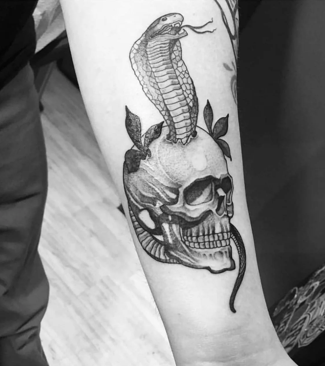 Snake wrapped around skull tattoo by Gonzalo Chavez