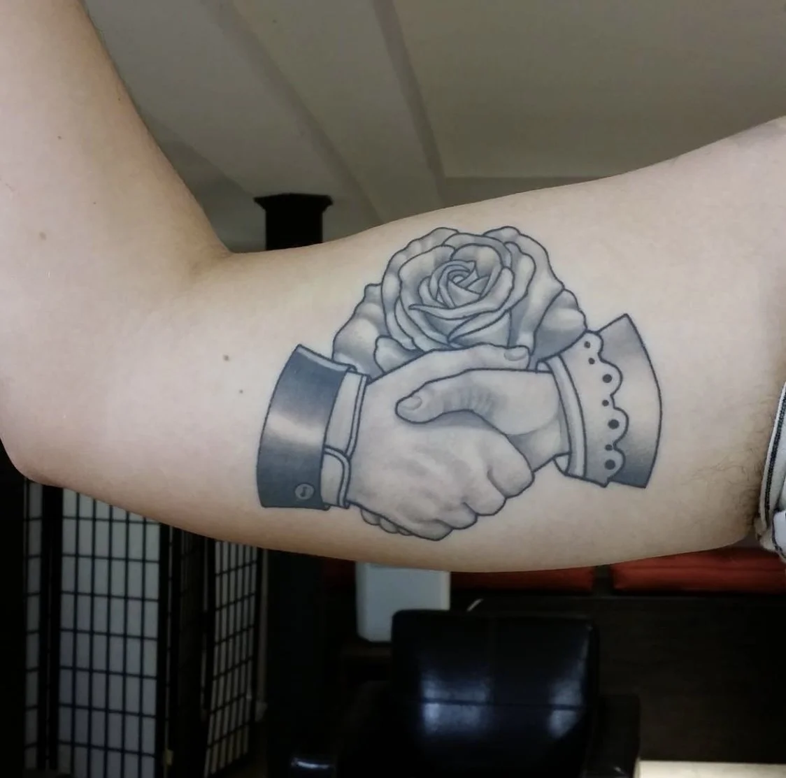 Classic handshake holding rose tattoo by Gonzalo Chavez