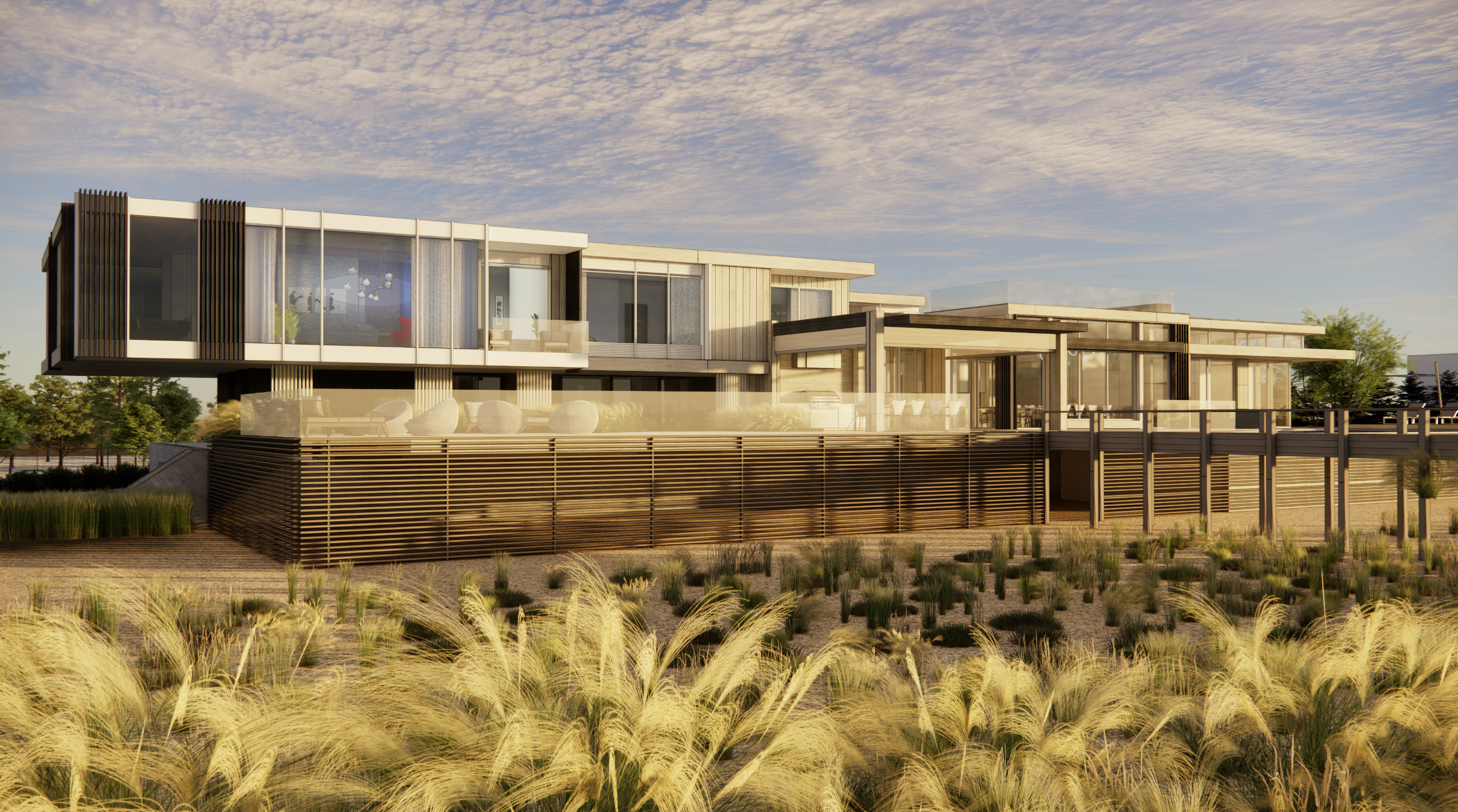 Modern multi-level house with large windows, wood accents, and outdoor balconies, surrounded by a landscaped yard with ornamental grasses under a cloudy sky.