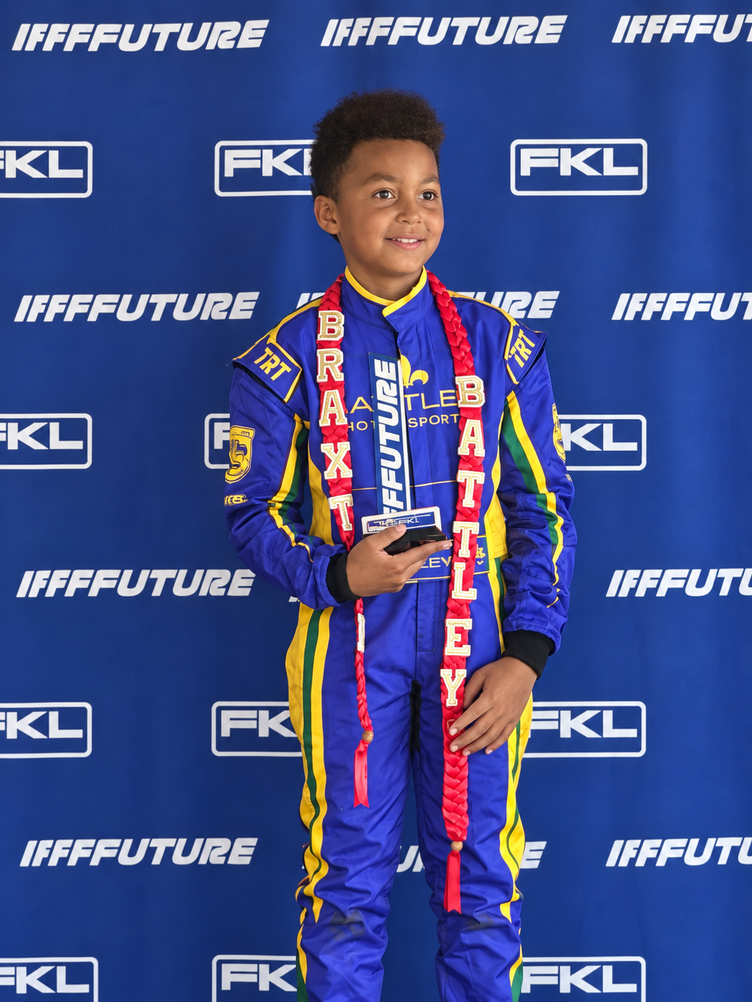 Braxton holding his first FKL Regional Series podium trophy in his purple and gold Battley Motorsports suit