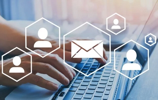 Person typing on a laptop with social media icons and email symbol overlay
