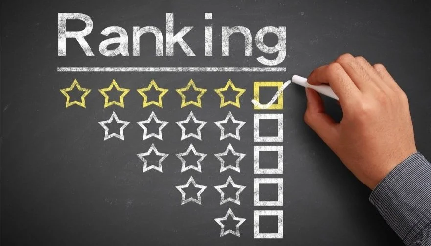 A hand is marking the first star in a five-star rating system on a blackboard, with the word  "Ranking" and the star ratings drawn underneath. The first row of stars is filled in yellow, indicating a one-star rating.