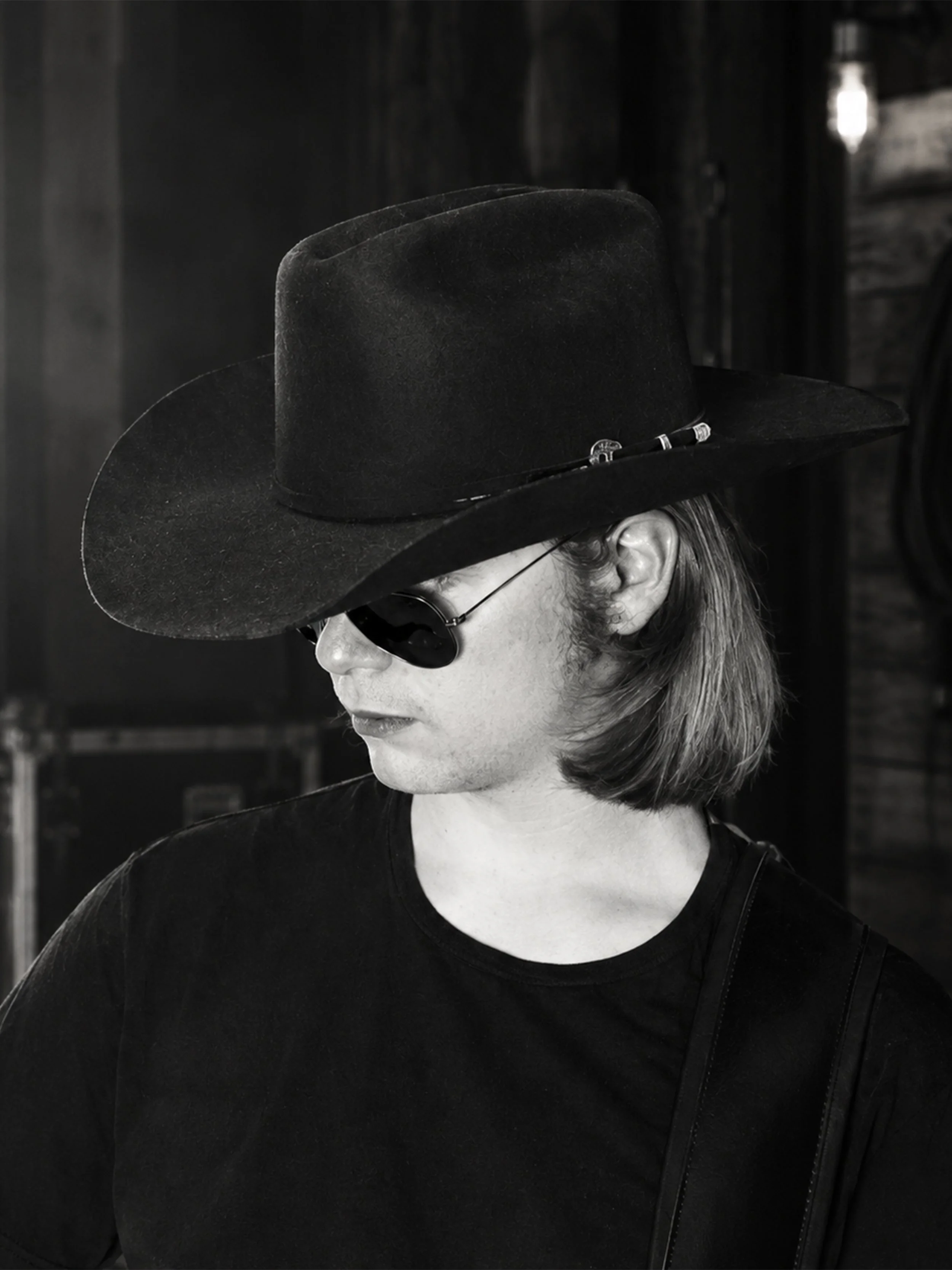 Black-and-white portrait of Vaughn Reinert wearing a cowboy hat and sunglasses.