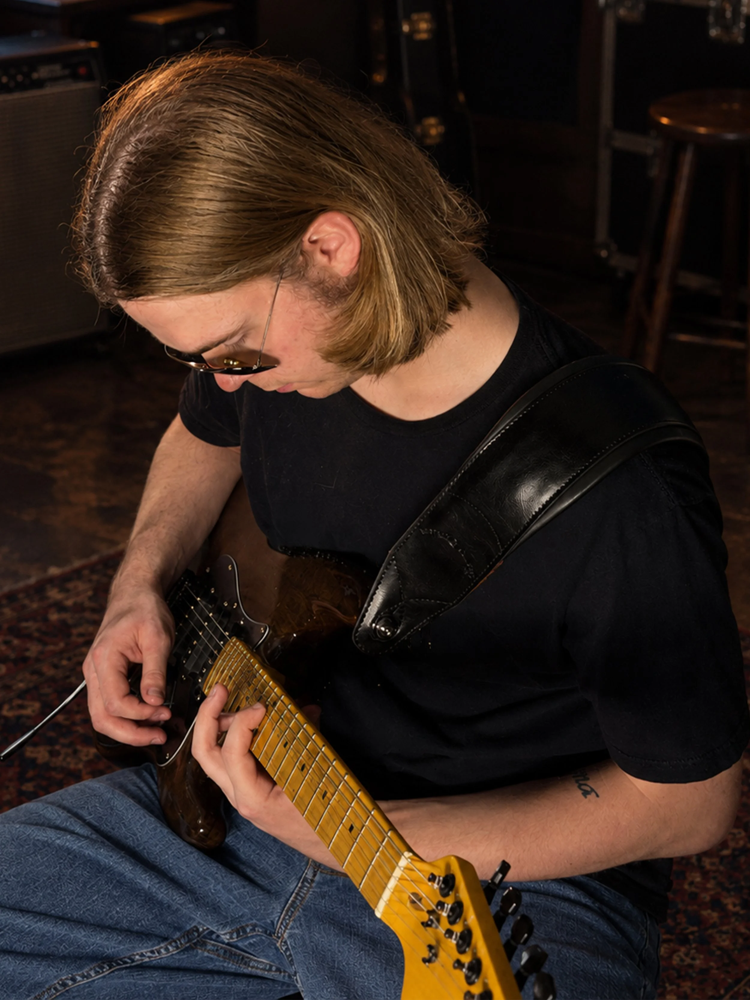 Vaughn Reinert playing electric guitar in a recording studio.