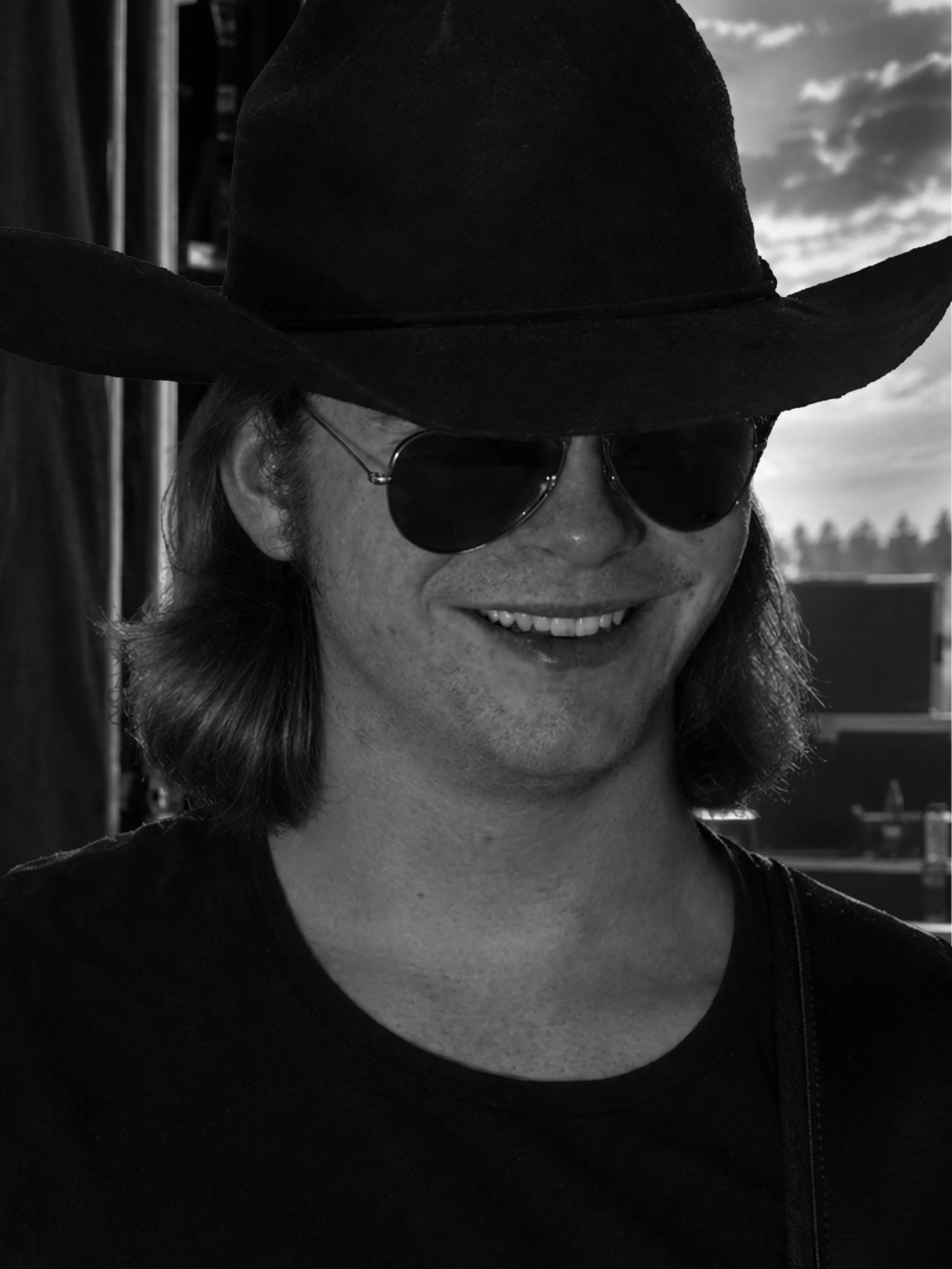 Black-and-white portrait of Vaughn Reinert wearing a cowboy hat and sunglasses.