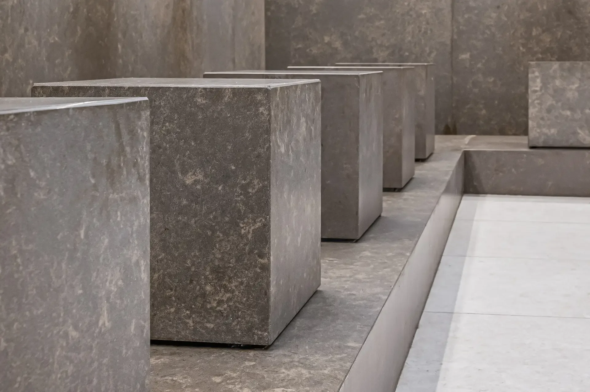 Rows of dark stone rectangular blocks in a minimalist modern architectural interior
