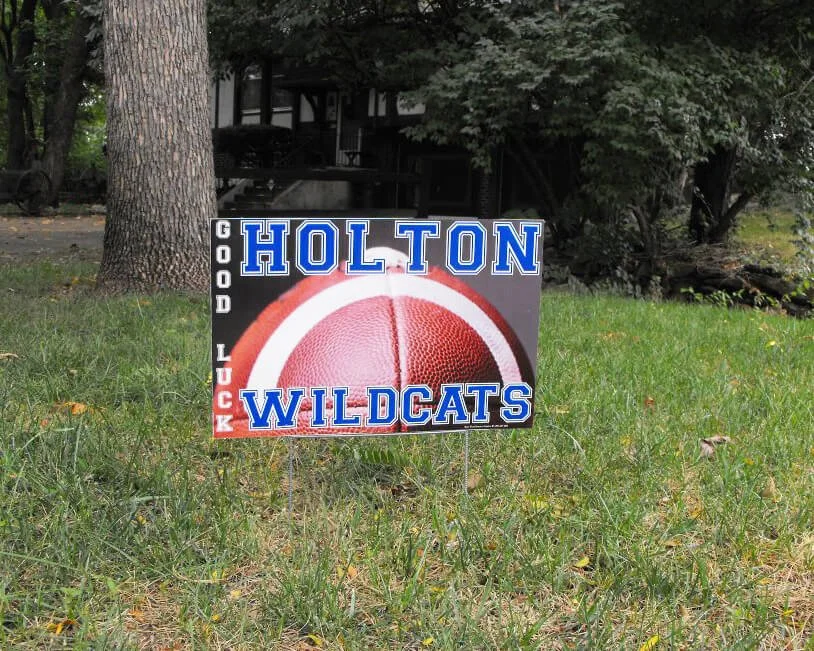 Sign in a grassy yard with a football and the words "Holton Wildcats" and "God Luck"
