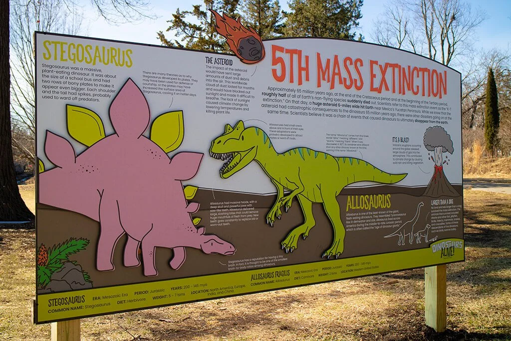 Educational outdoor sign about the extinction of the dinosaurs, featuring colorful illustrations of Stegosaurus and Allosaurus, with informative text and a volcano illustration.