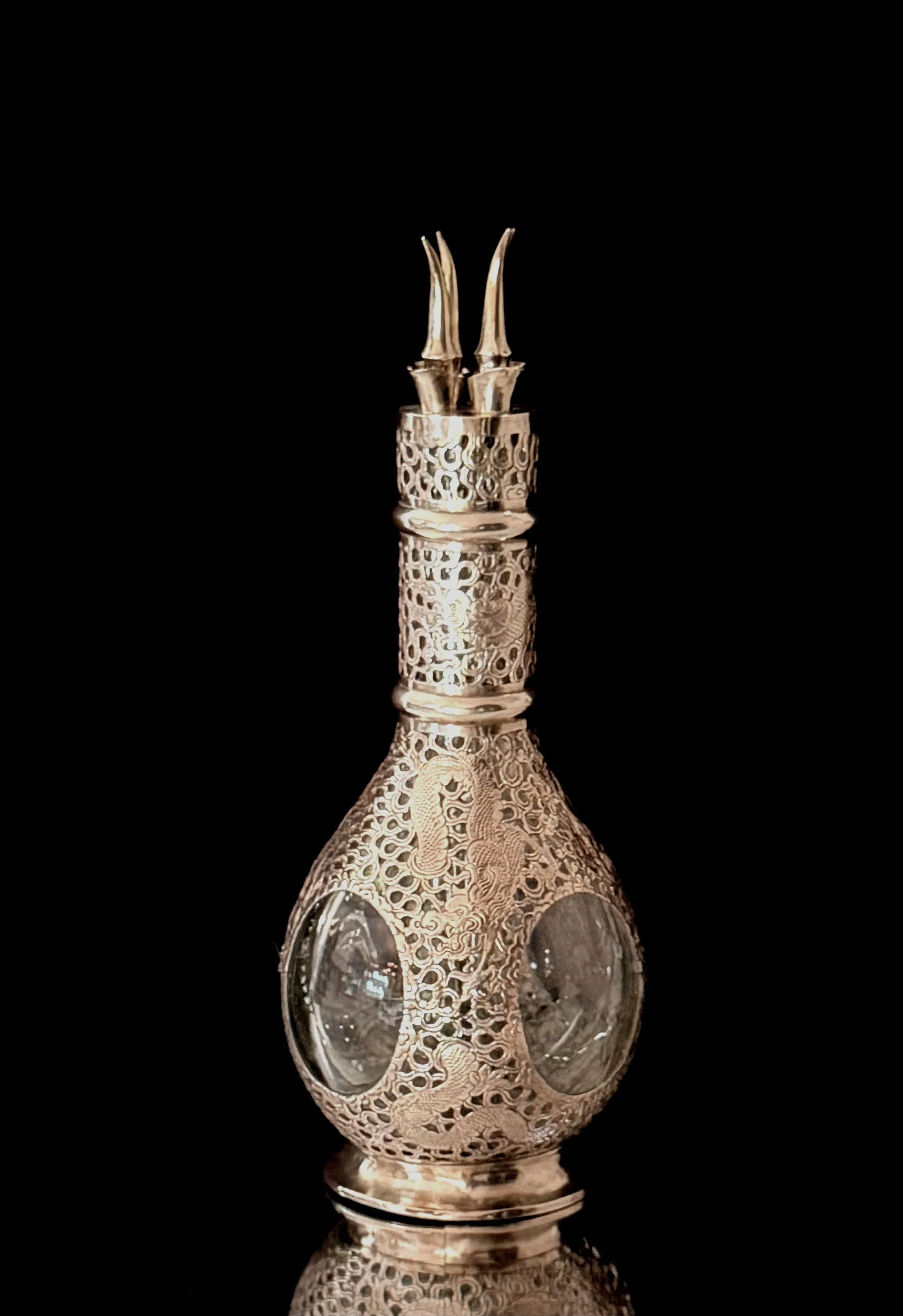 A four chamber sterling silver decanter engraved with a oriental themed motif