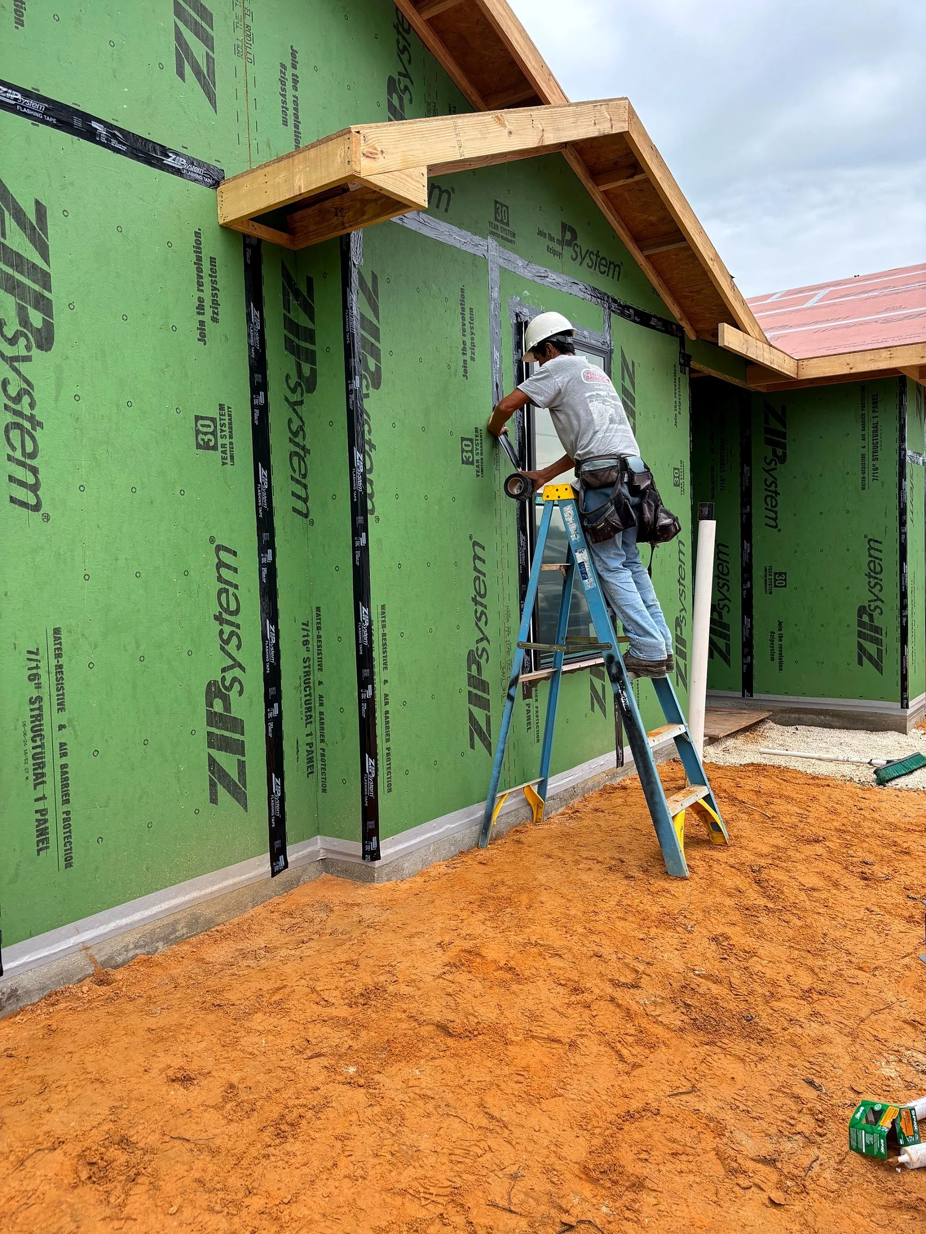 Element Homes crew taping window flashing on ZIP System wall sheathing