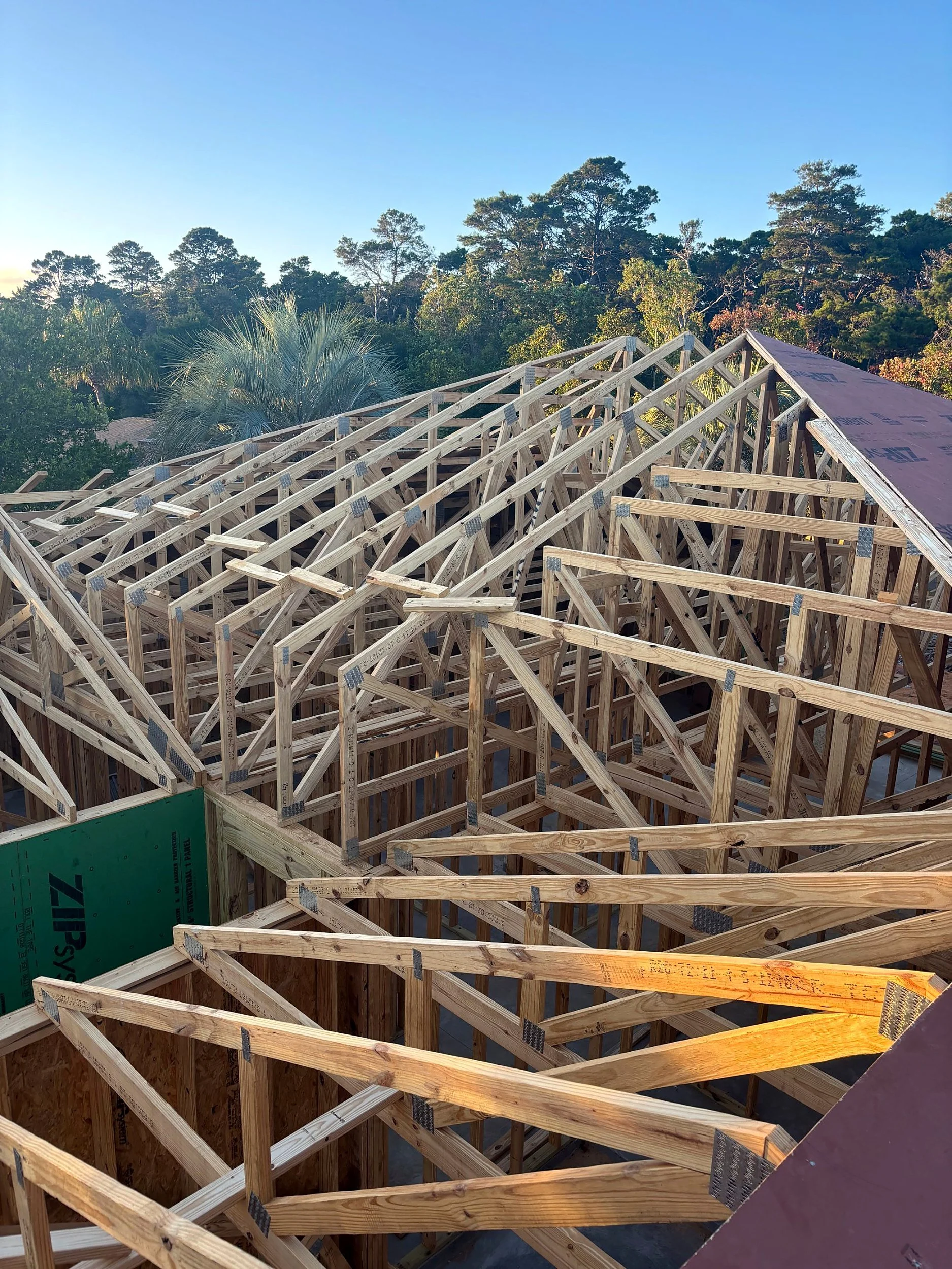 Roof trusses set on a new Element Homes build in Bay County, Florida, at golden hour