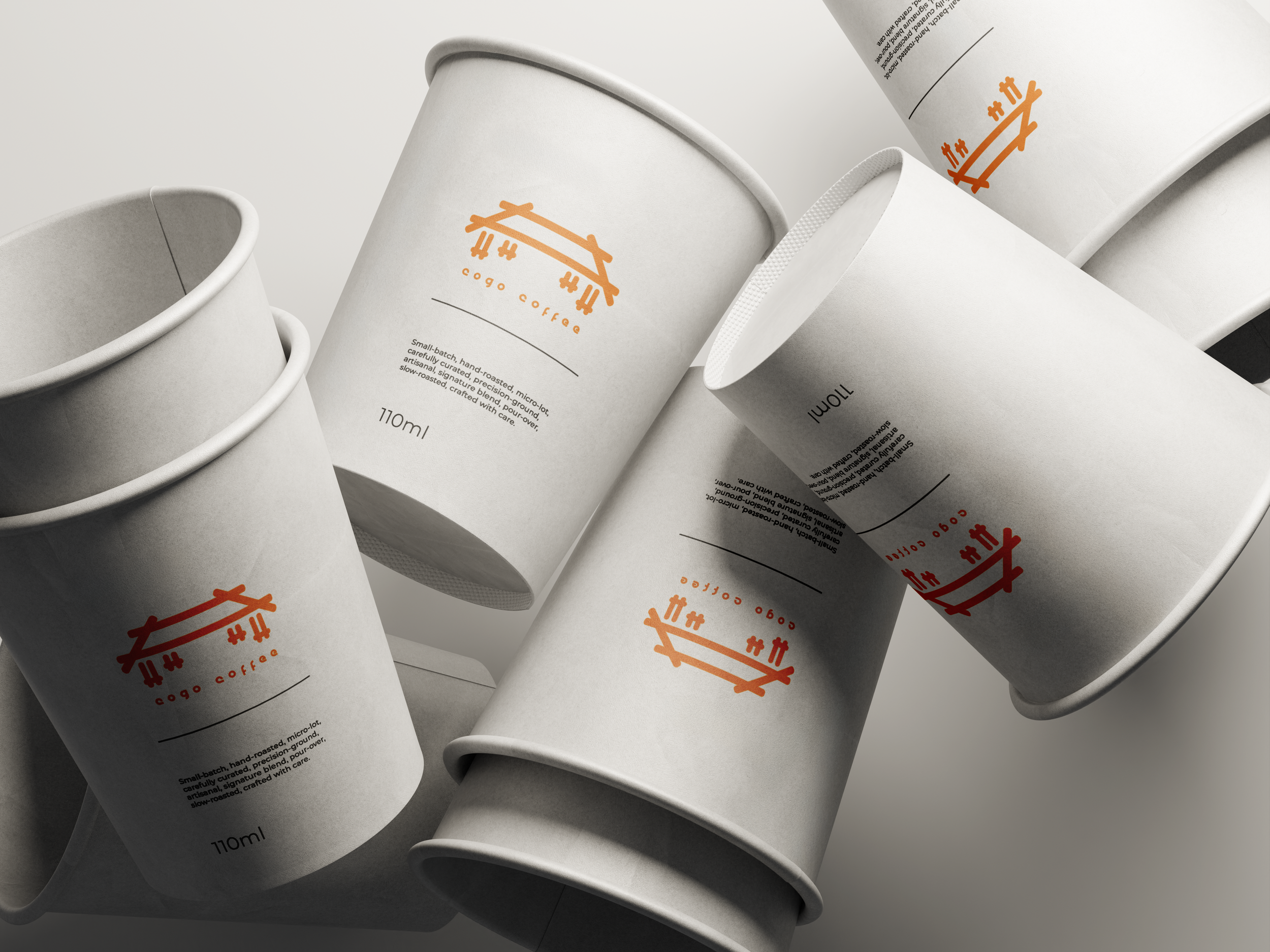 A group of white disposable coffee cups with orange logo and black text, laid on a white surface.