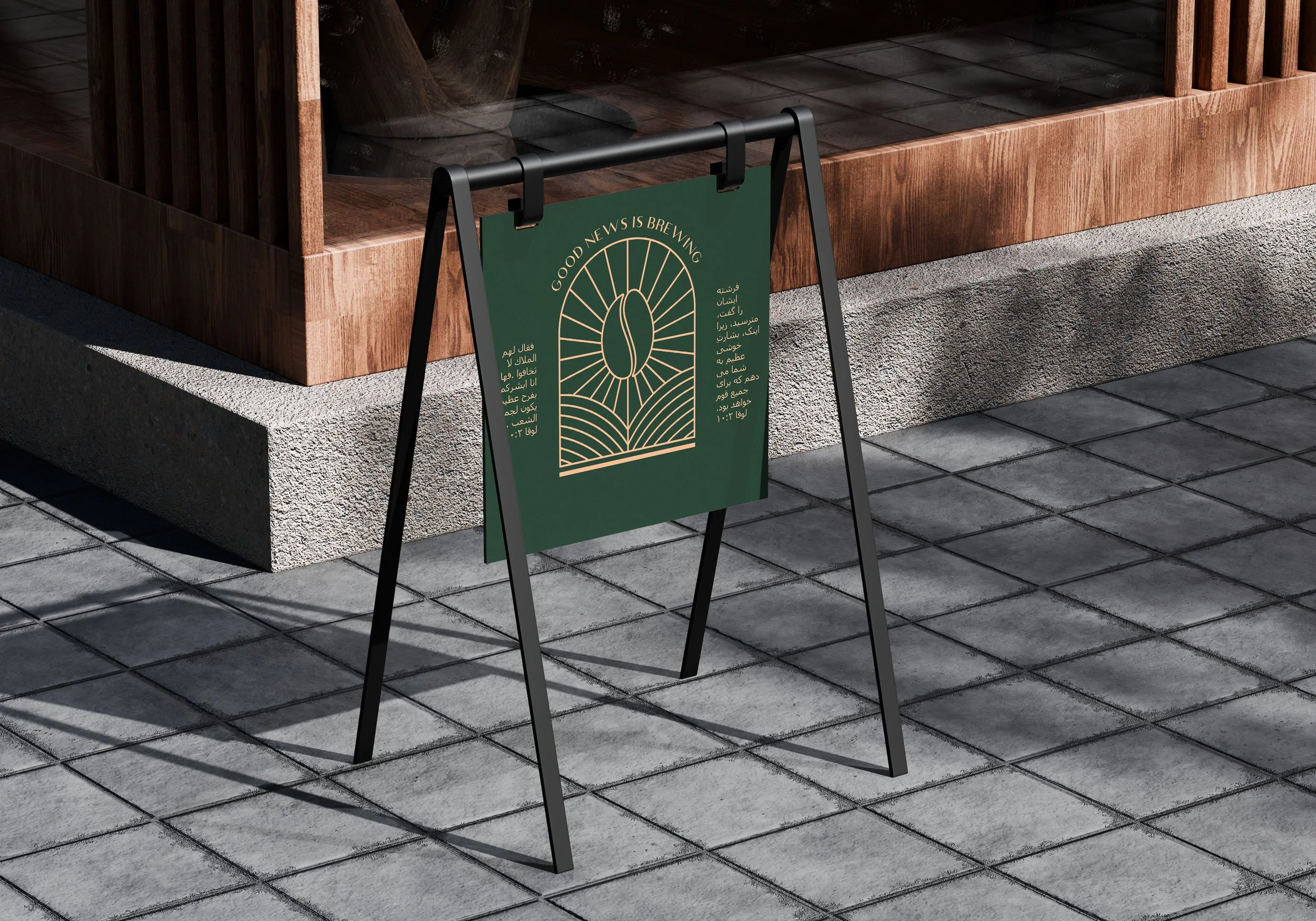 A green sandwich board sign with gold design and text outside on a sidewalk, next to a wooden structure with trees visible inside.