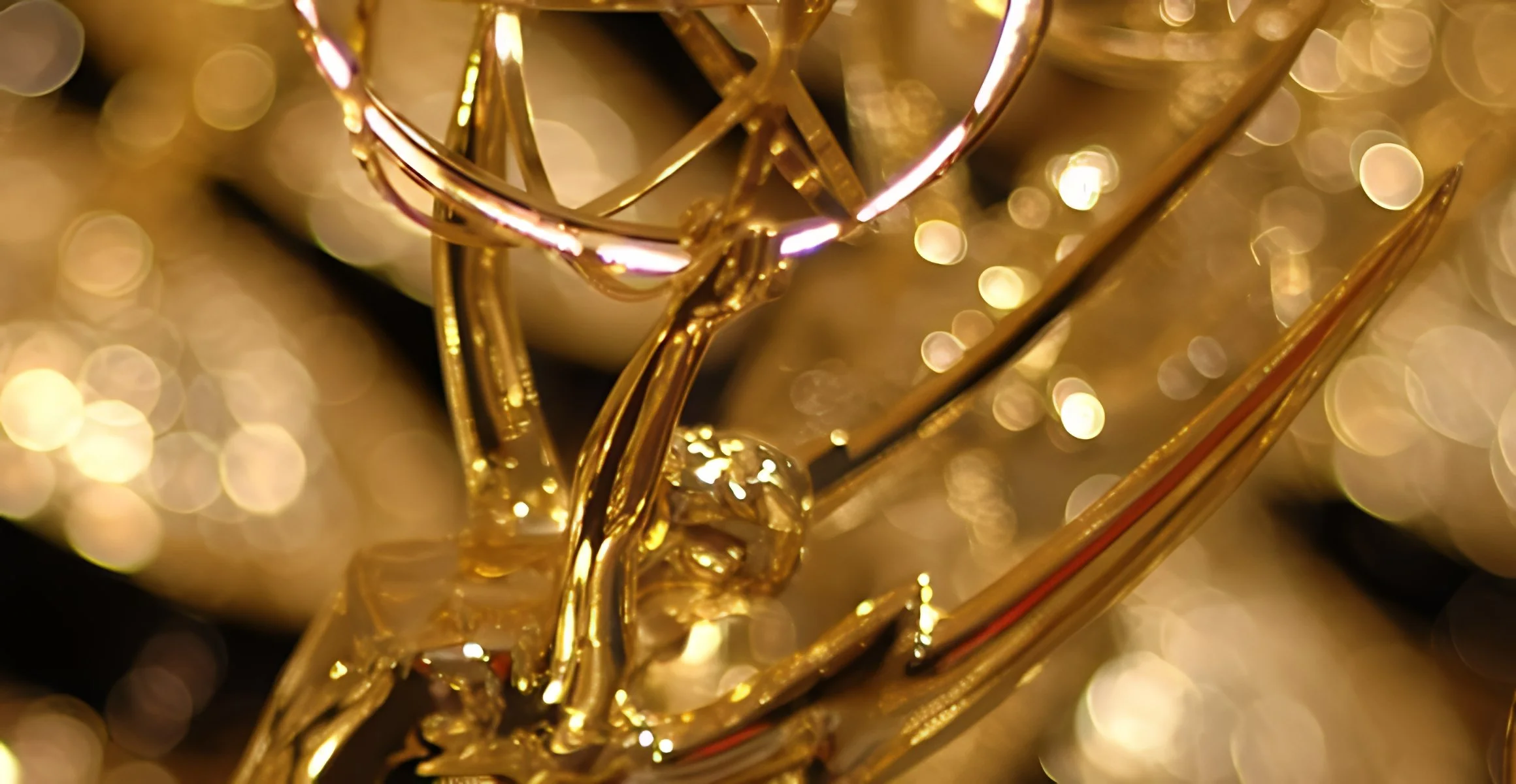 Close-up of a golden star-shaped ornament with small light reflections and blurred lights in the background, creating a festive holiday atmosphere.