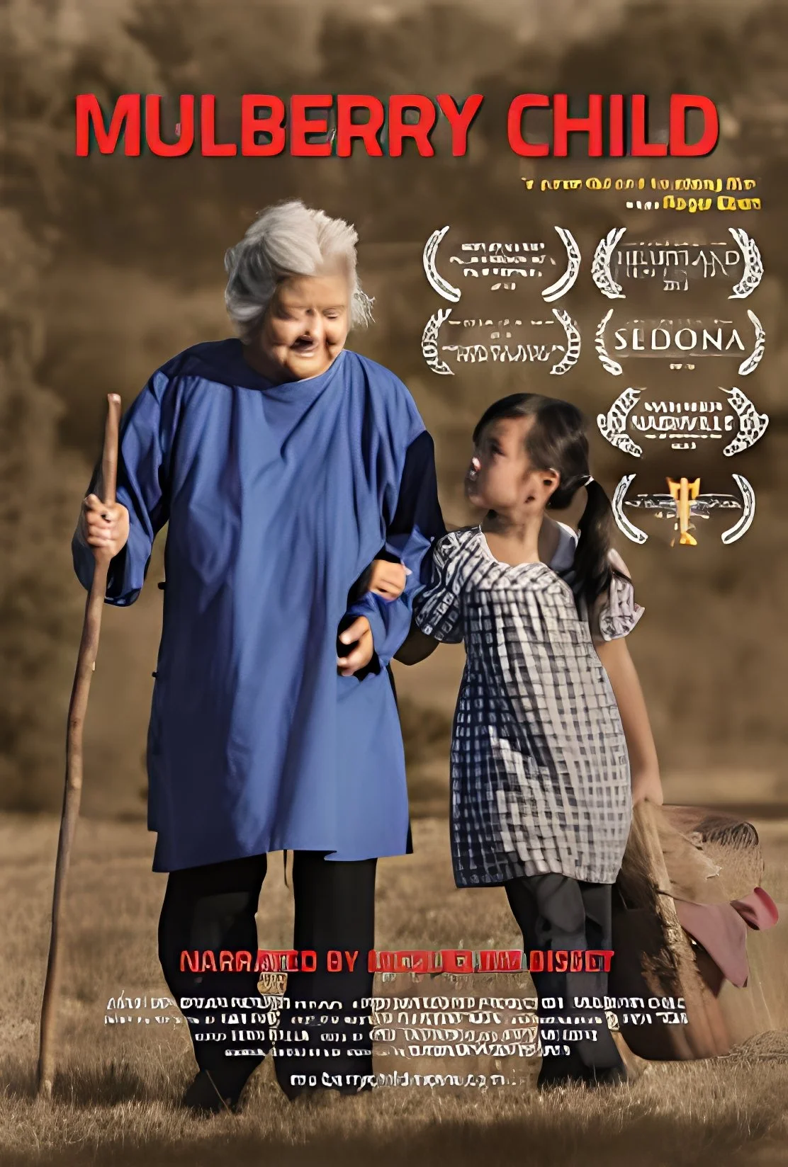 A woman dressed as an elderly person with gray hair, wearing a blue cloak, holding a wooden staff, and talking to a young girl in a checkered dress. There is a dog lying on the ground nearby. The background is a plain outdoor setting.