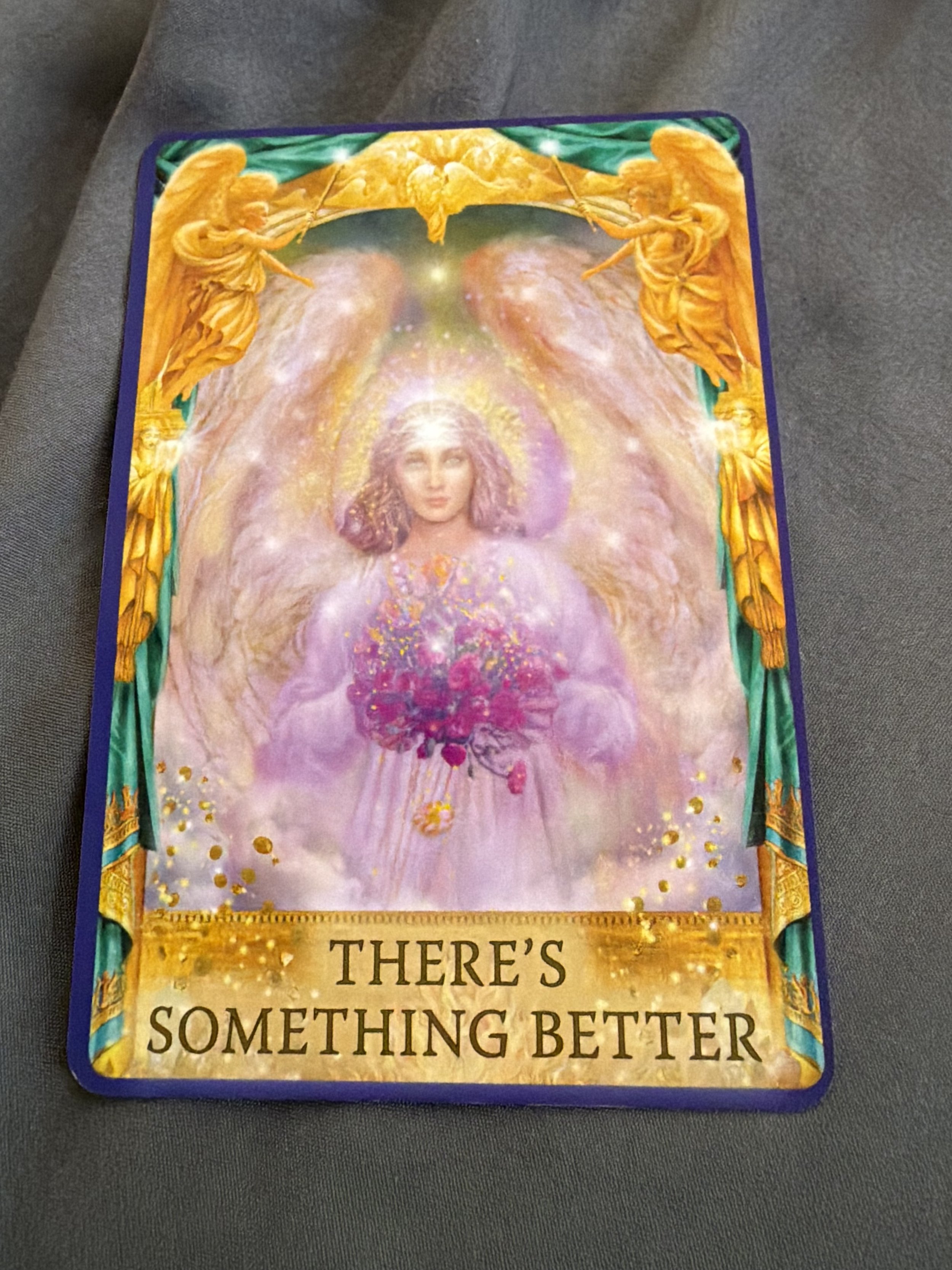 Tarot card with an angelic figure surrounded by pink, purple, and yellow tones and a quote reading "There's something better".