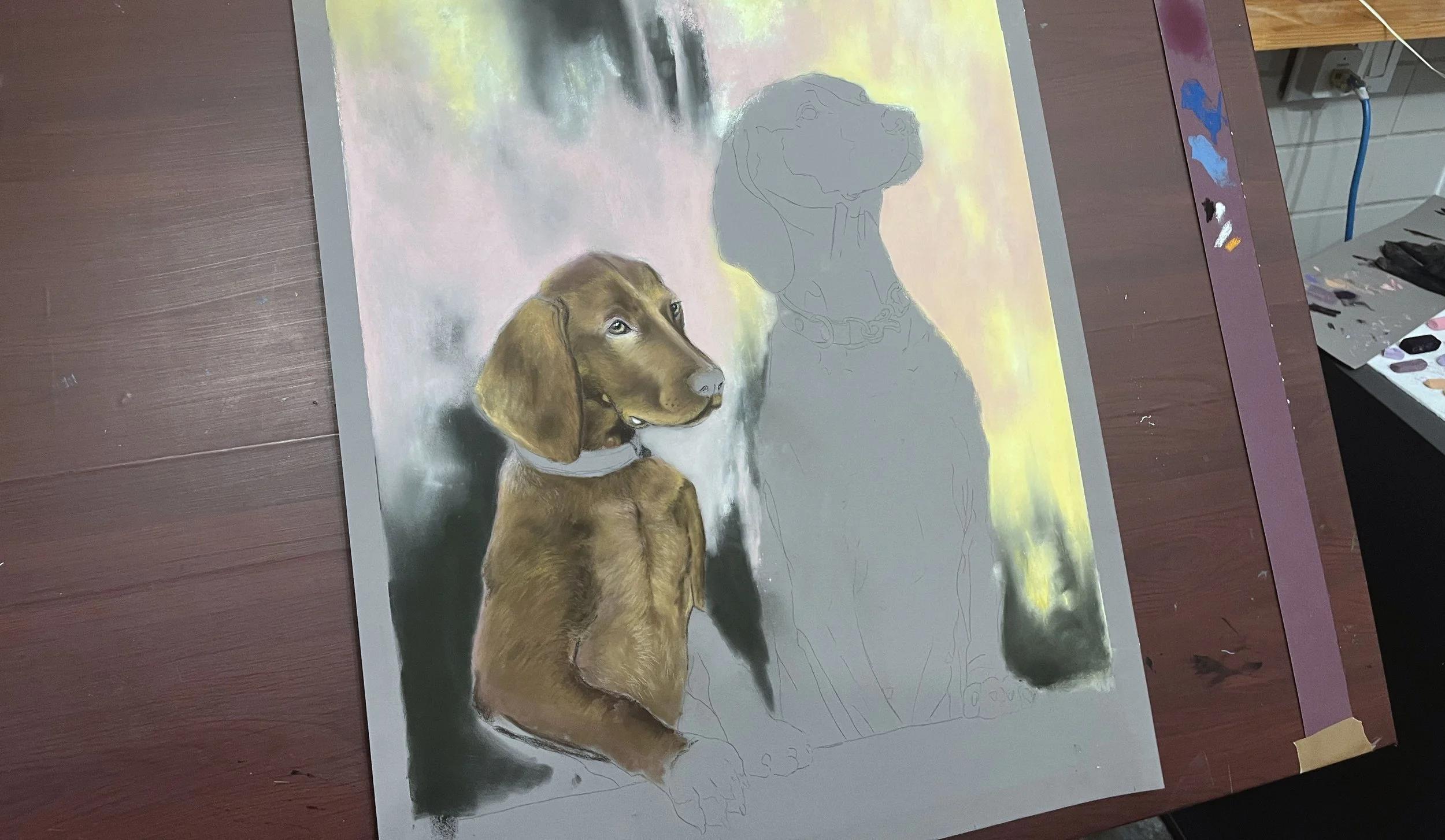 A partially completed painting of a brown dog with a collar, with an outline sketch of the dog's head and upper body on a canvas. Various paints and brushes are visible nearby on a table.