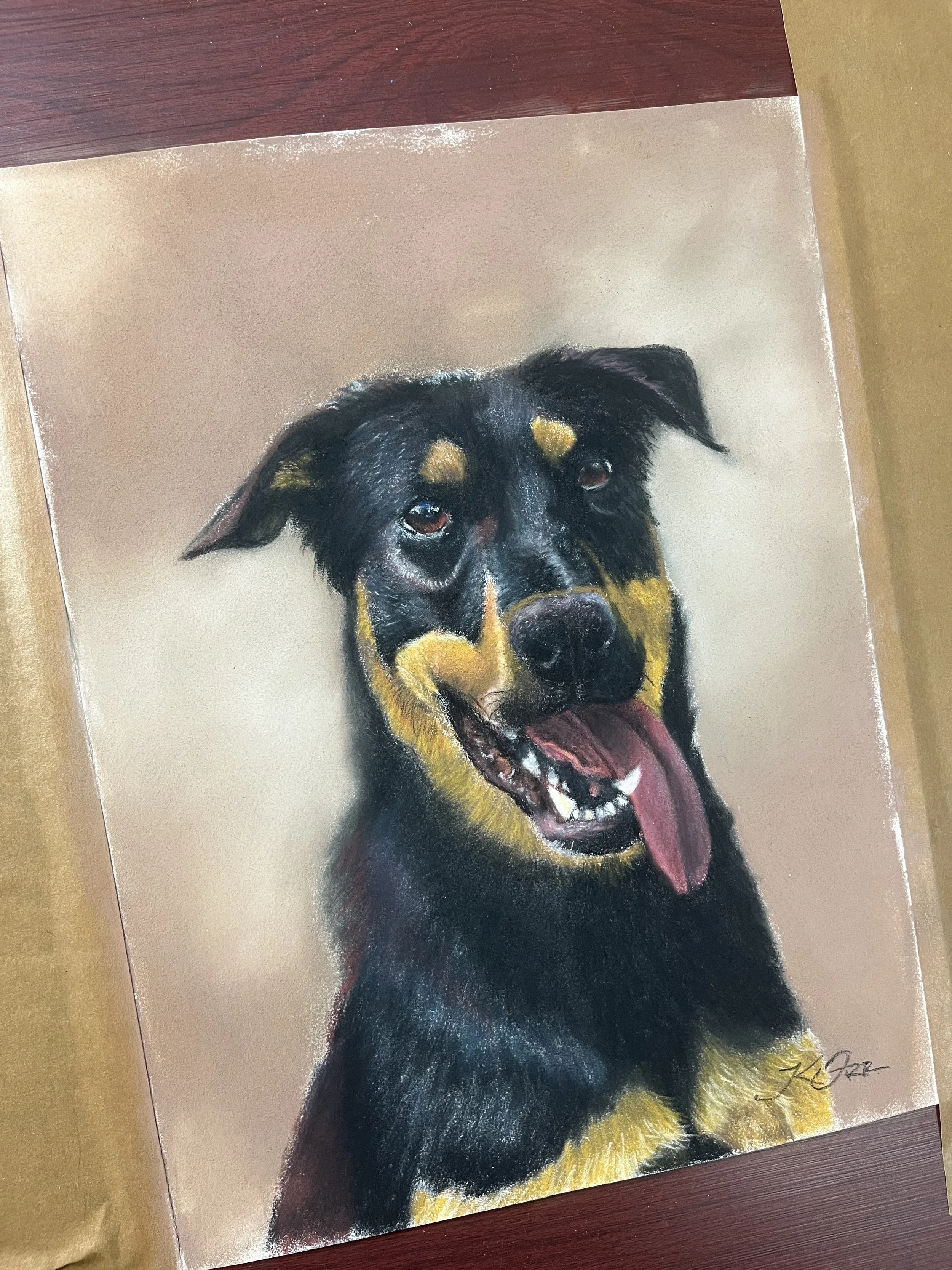 Portrait of a black and tan dog, possibly a Rottweiler, with a happy expression, tongue out, on a tan-colored background.