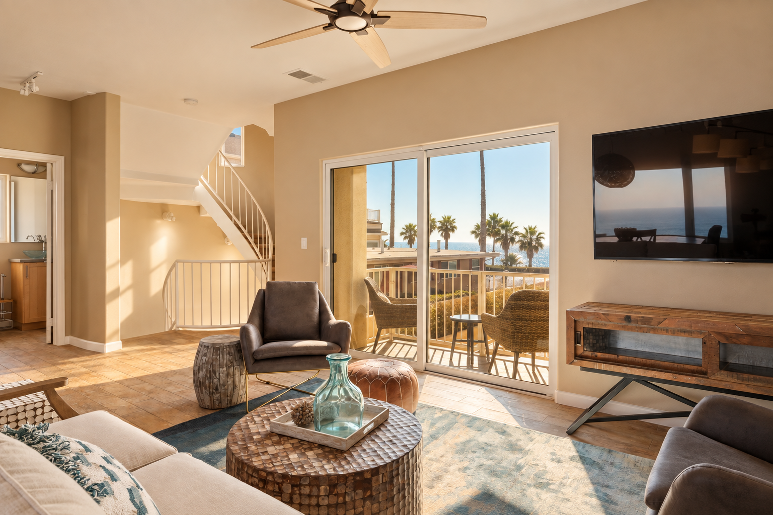 Living room at Castle Tower Arena with balcony, palm tree and ocean views in Oceanside, California.
