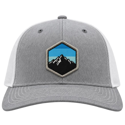 Gray and white trucker hat with a mountain patch on the front