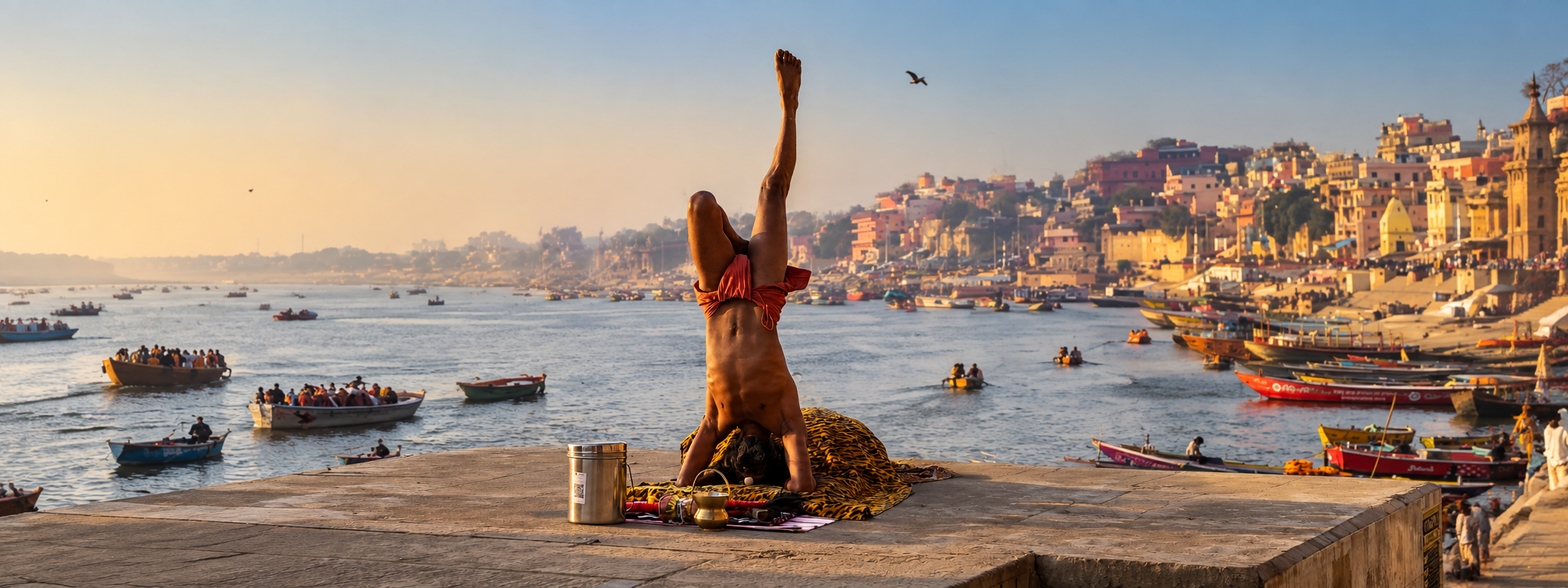 SAdhu che pratica yoga su una piattaforma sul Gange, con barche e ghats di Varanasi sullo sfondo al tramonto