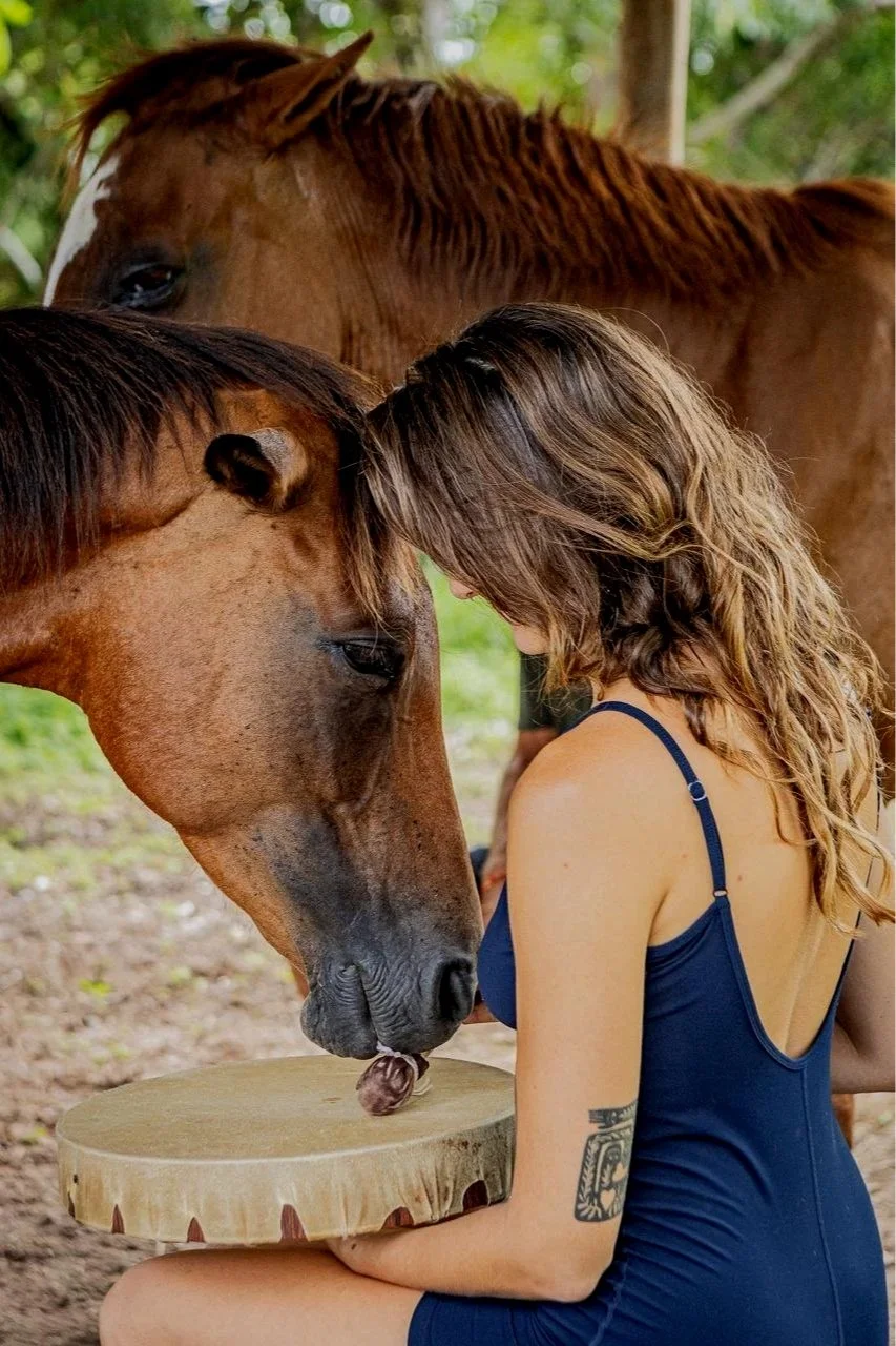 A woman resting her forehead on a horse at the Healing with Horses retreat in Costa Rica