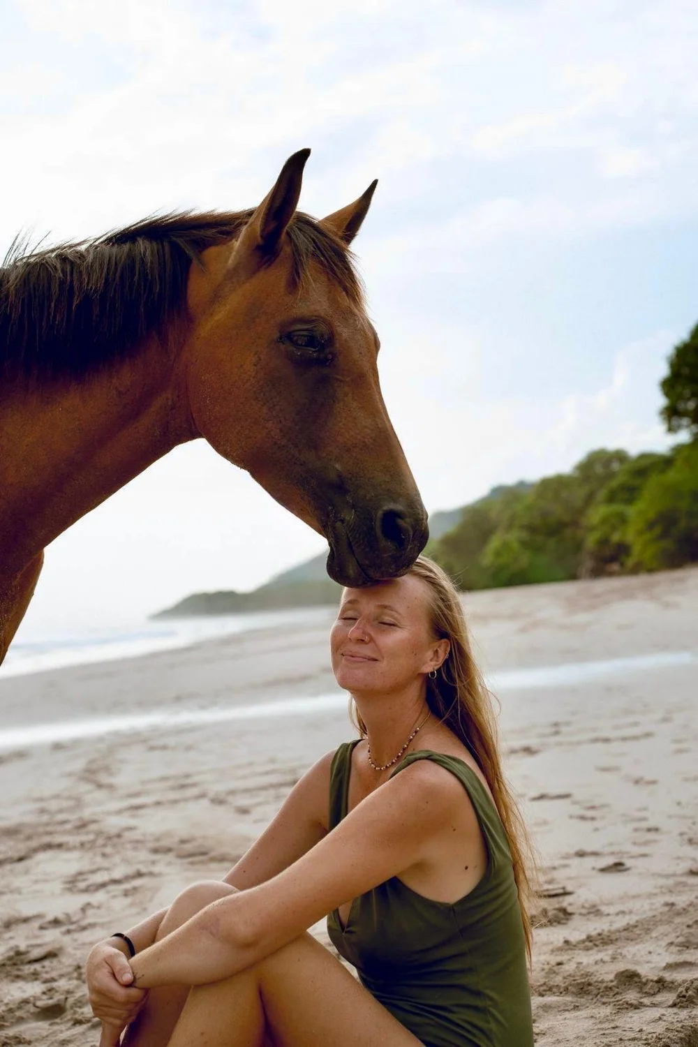 Apolline with one of her horses on the beach