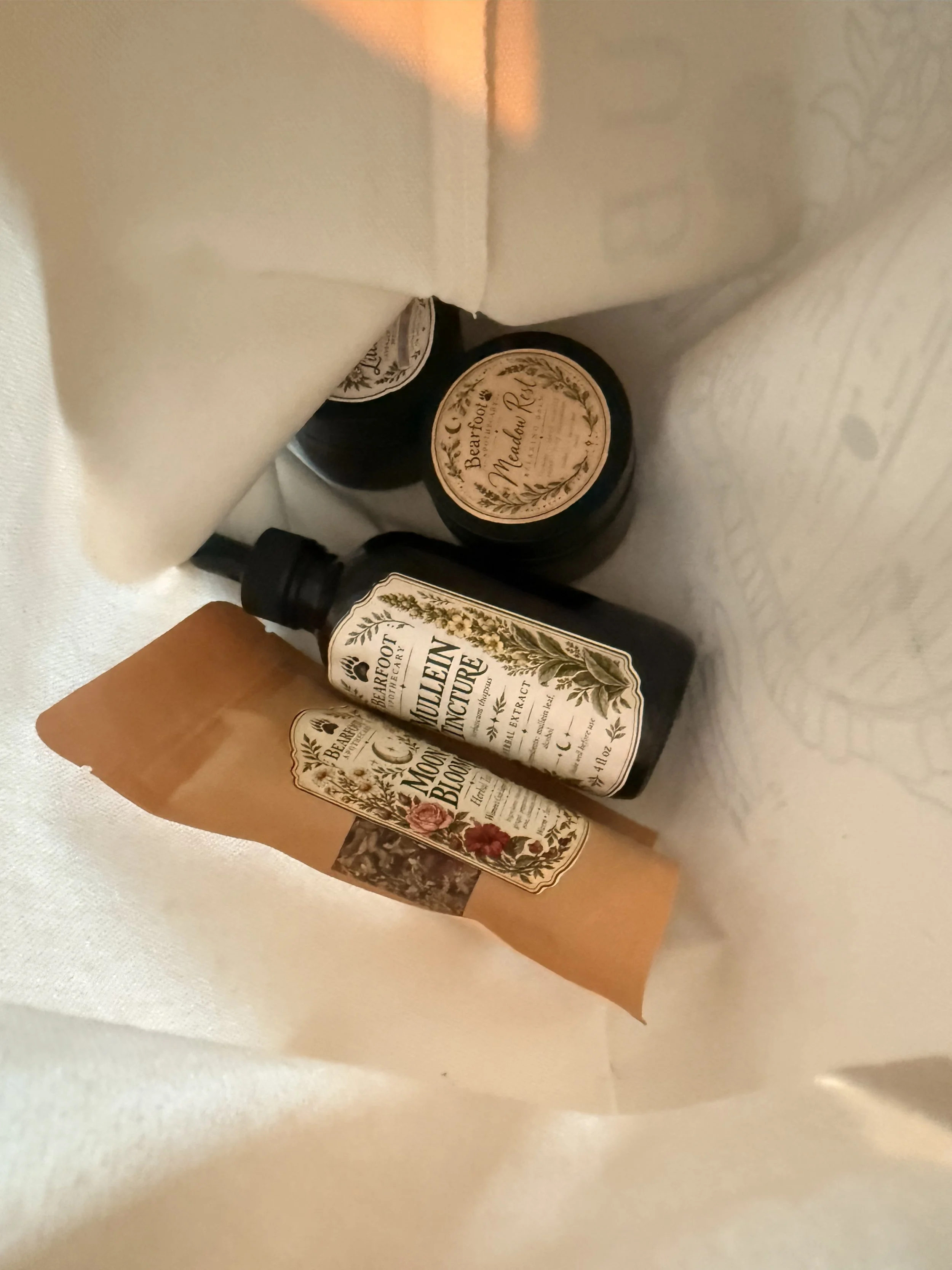 Decorative vintage-style botanical labels and cards arranged on white fabric, including text such as “Beautiful Nature” and “Moon Bloom.”