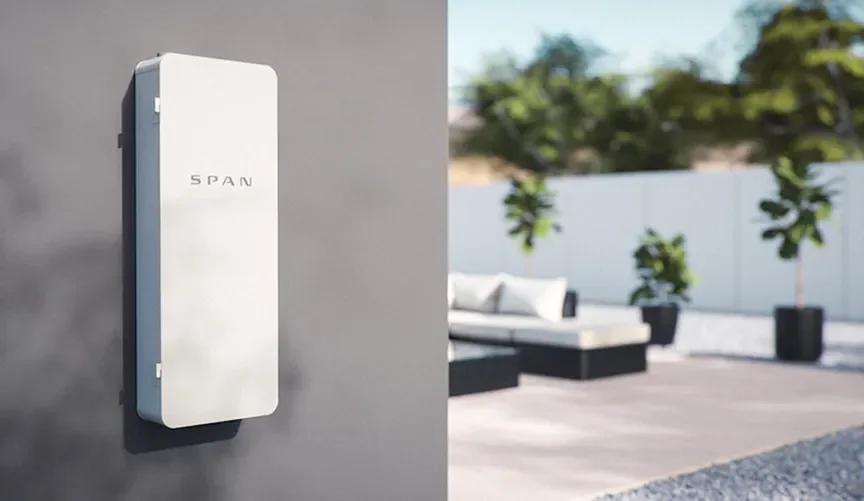 Outdoor view of a modern patio with a white fence, lounge seating, and potted plants, with a gray wall on which a white box labeled 'SPAN' is mounted.
