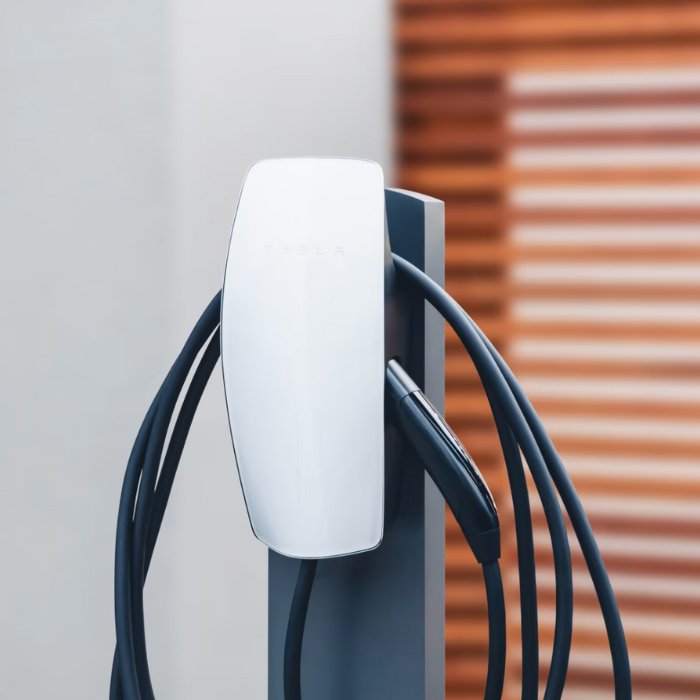 Tesla electric vehicle charger with multiple cords plugged in.