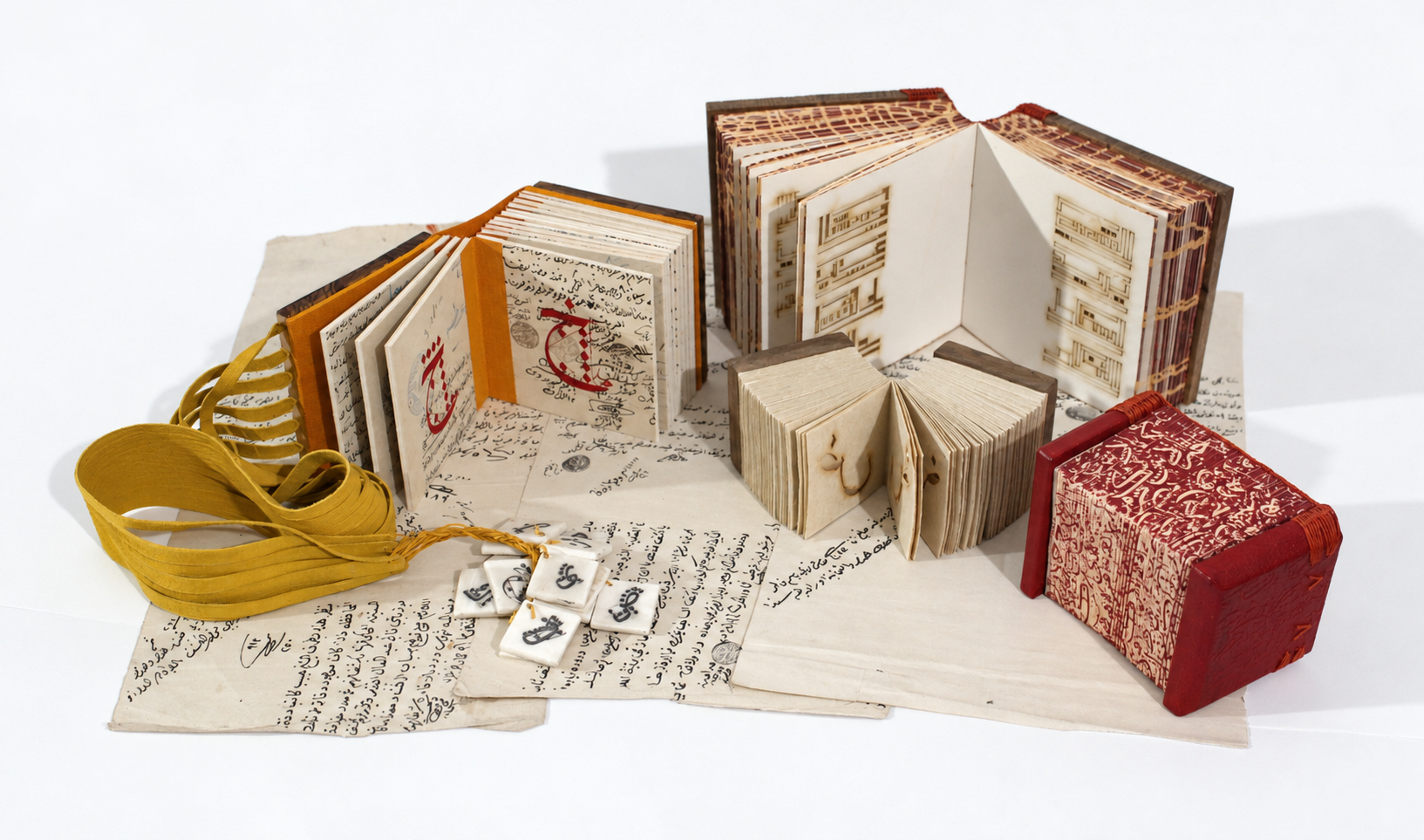 Artists’ books by Islam Aly arranged with handwritten pages, sculptural bindings, and calligraphic details.