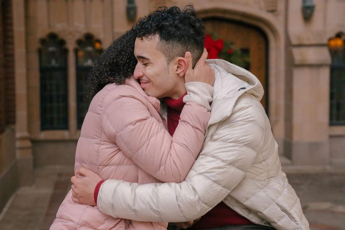 A Latino couple sharing a warm embrace outdoors