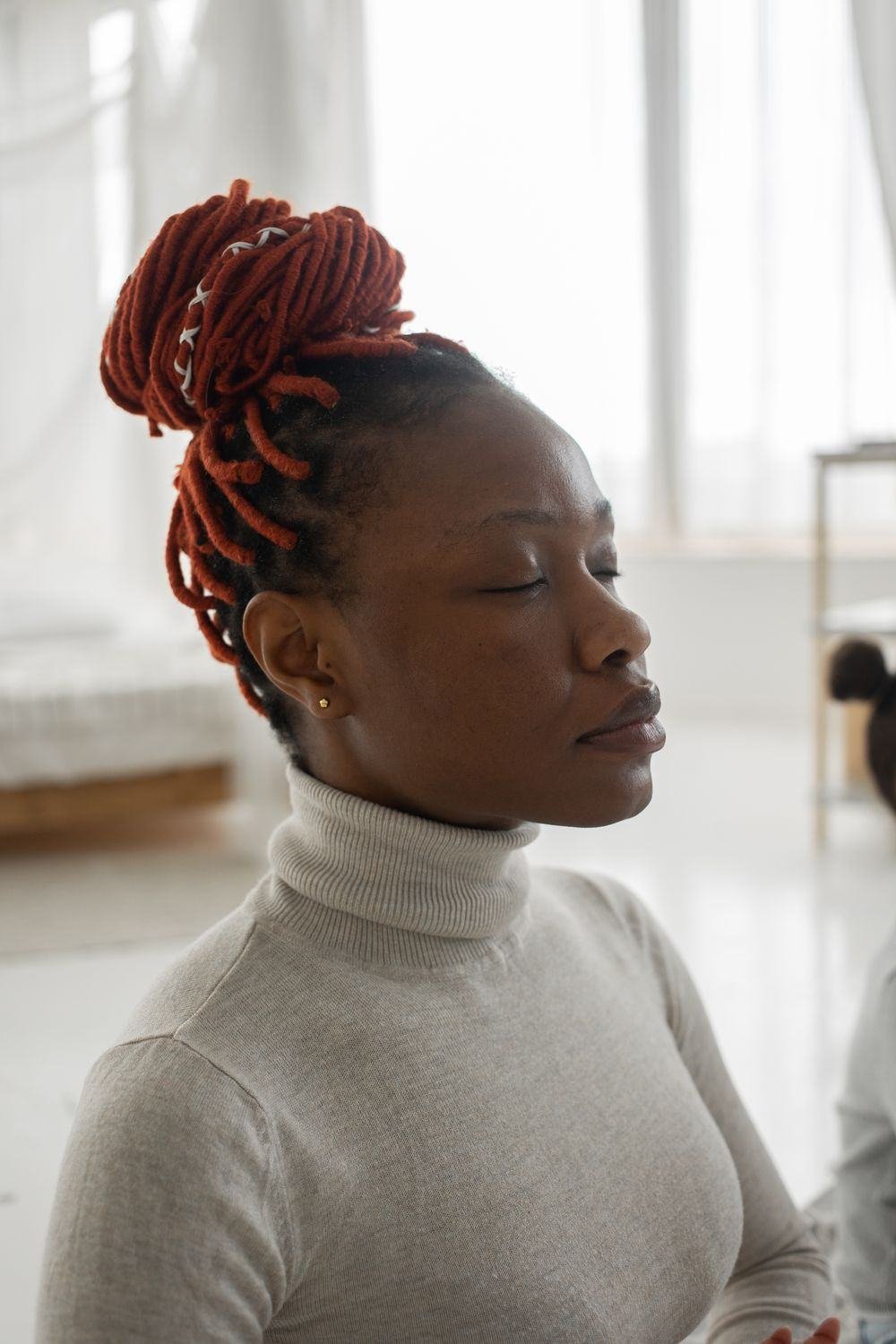 A Black woman resting peacefully with her eyes closed at home