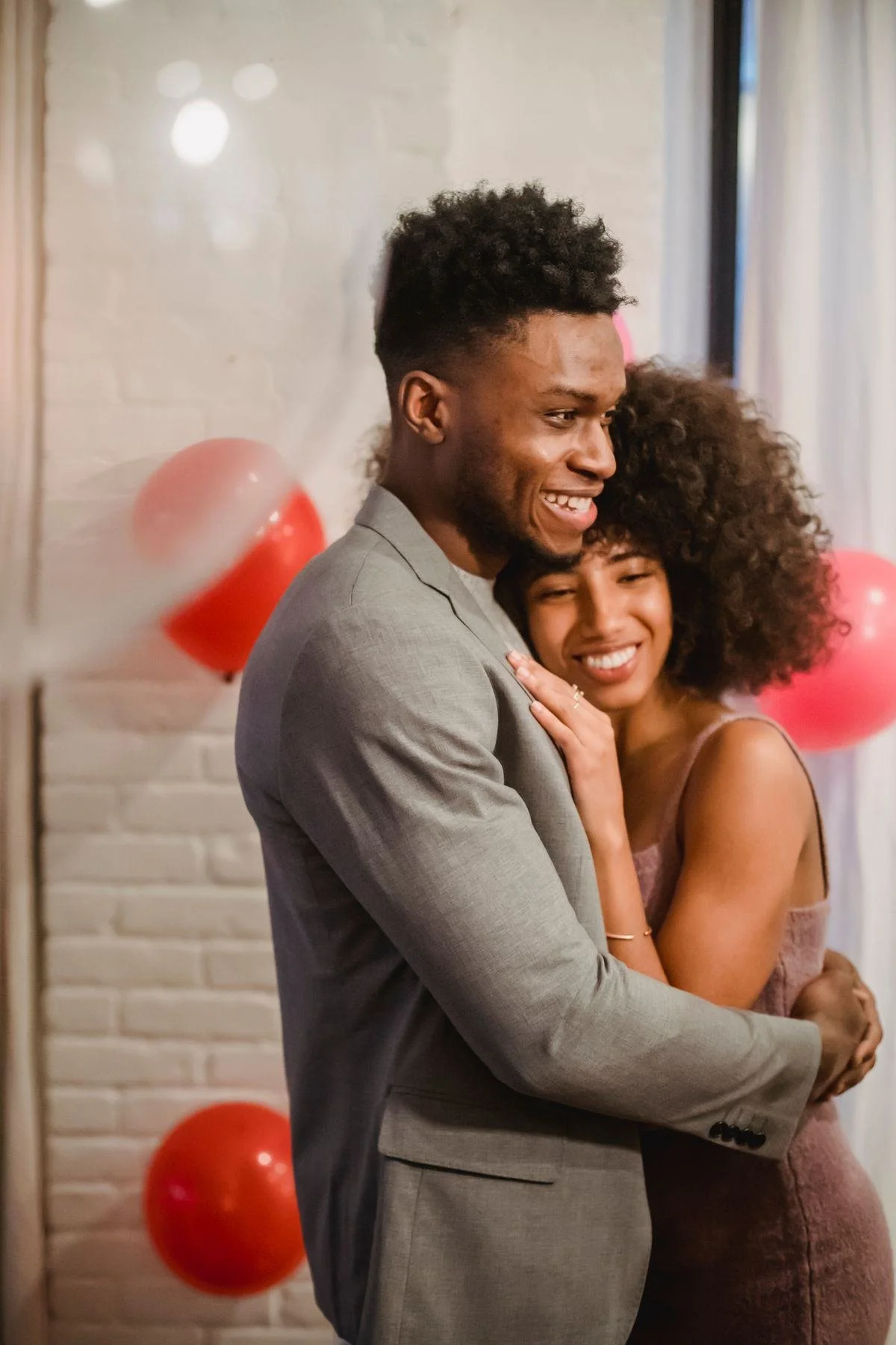A Black couple embracing and smiling at home