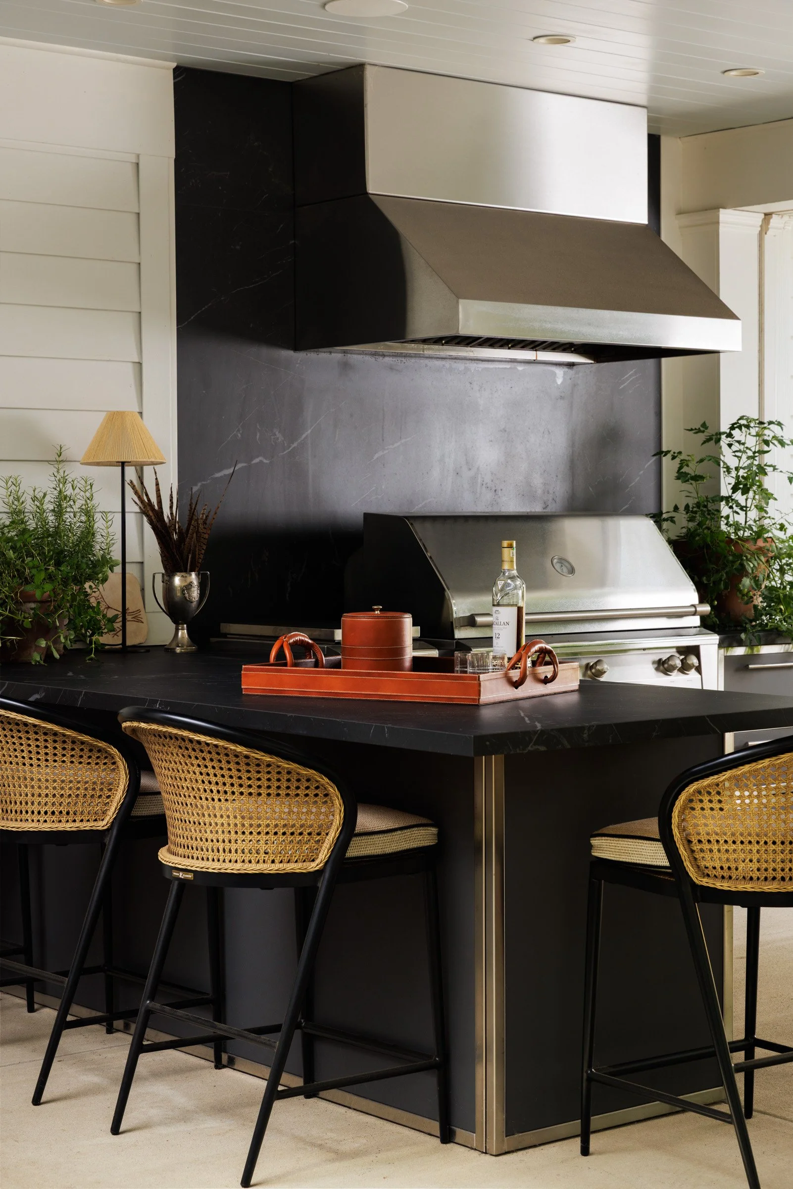Outdoor kitchen and bar seating beneath the covered terrace