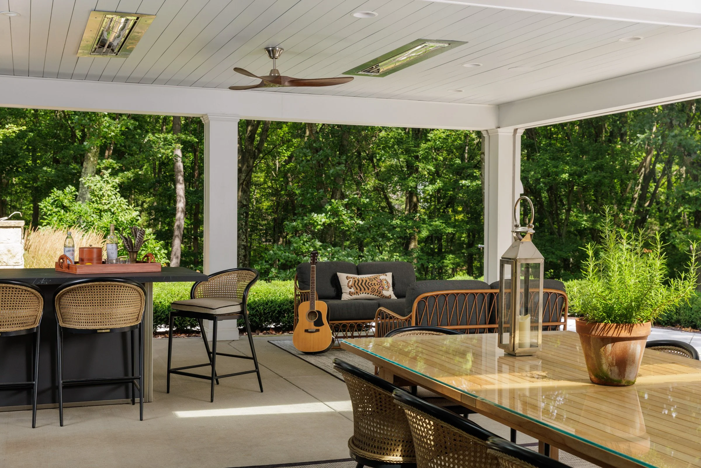 Covered outdoor dining and living area overlooking the trees