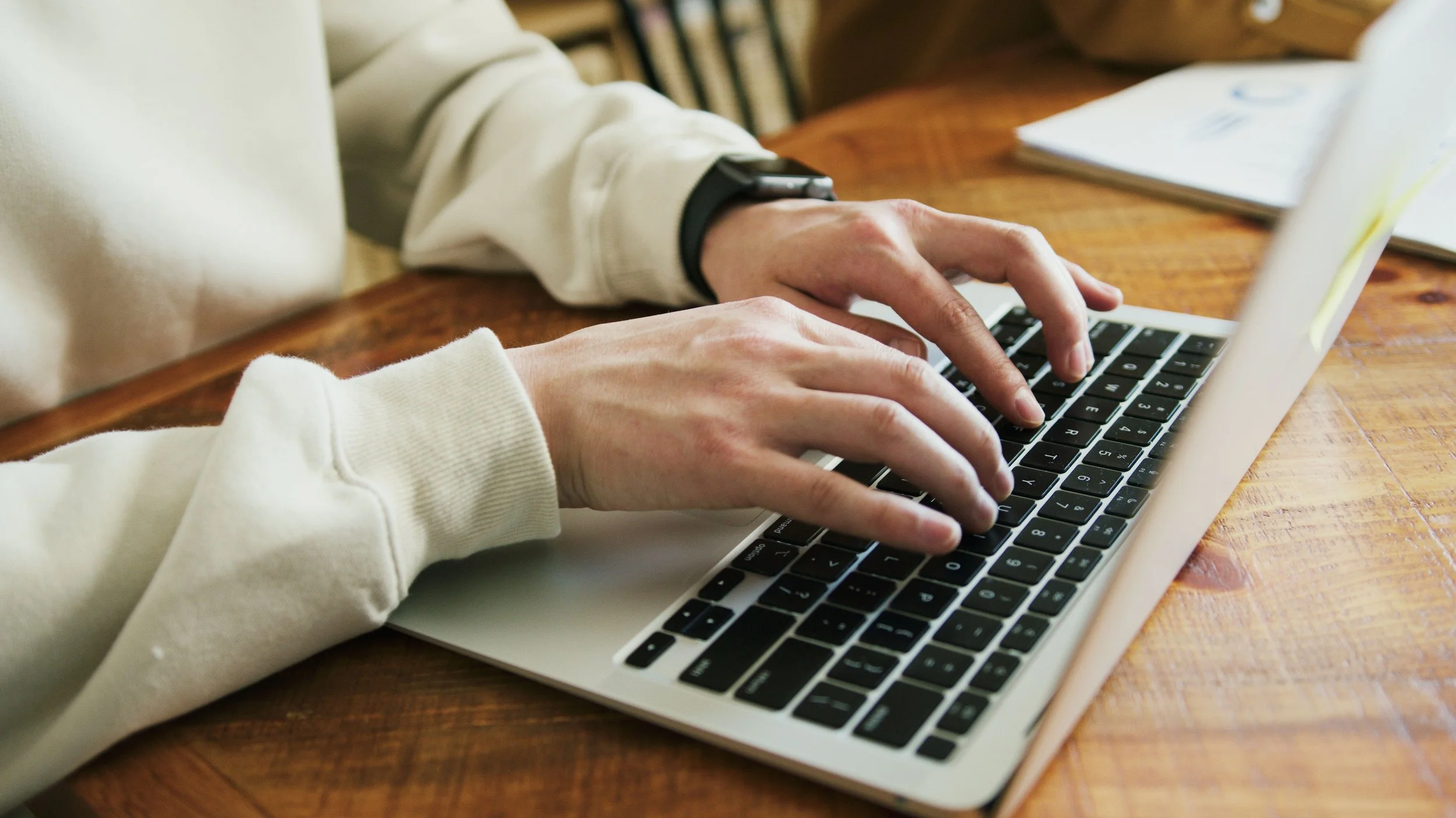 Hände auf einer Laptop Tastatur am schreiben