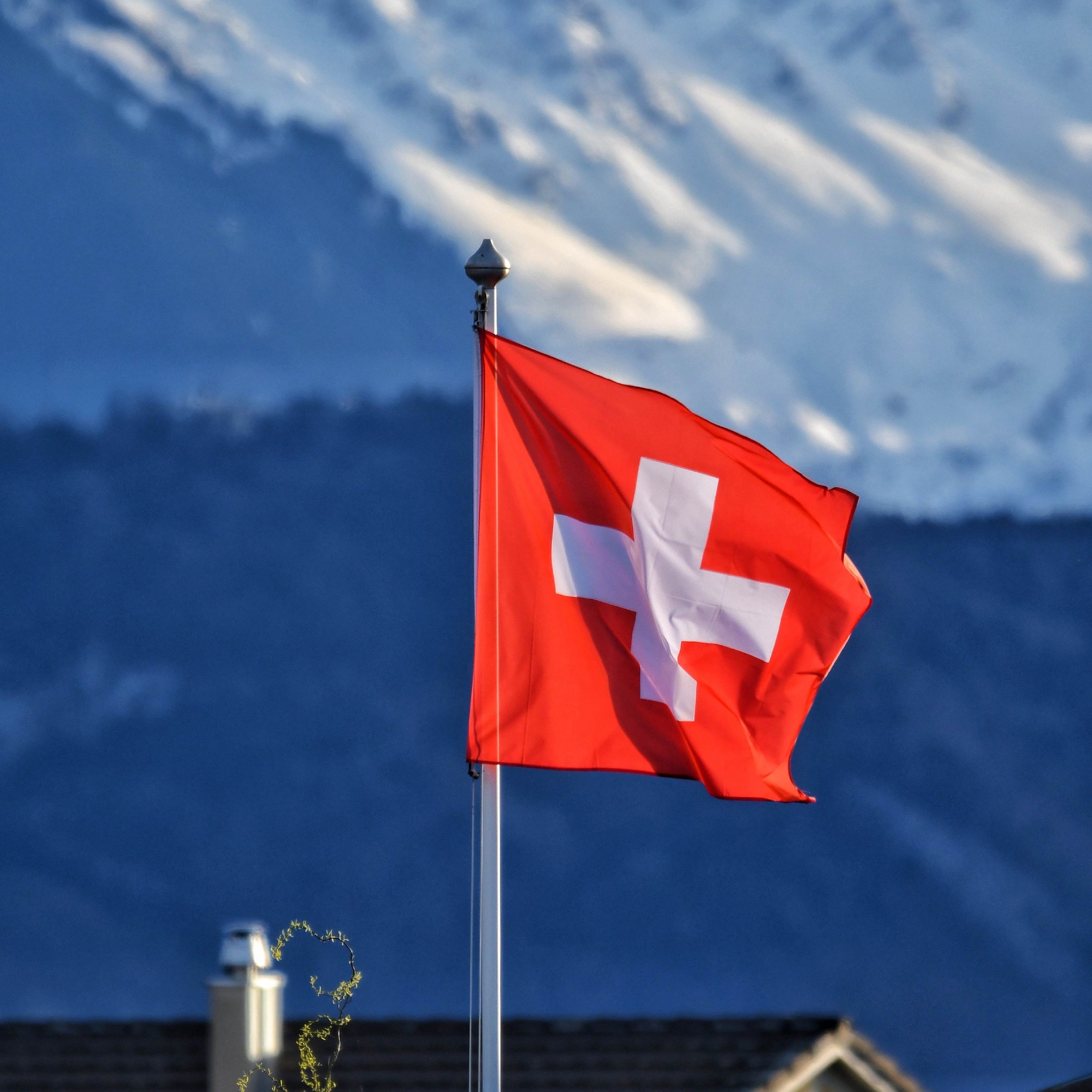 Schweizer Flagge mit Schweizer Berg im Hintergrund